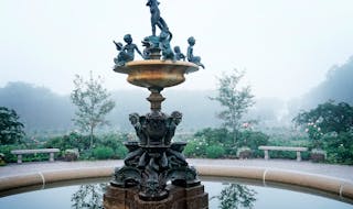 Heffelfinger fountain in the Lyndale Park Rose Garden in Minneapolis surrounded by morning mist.
