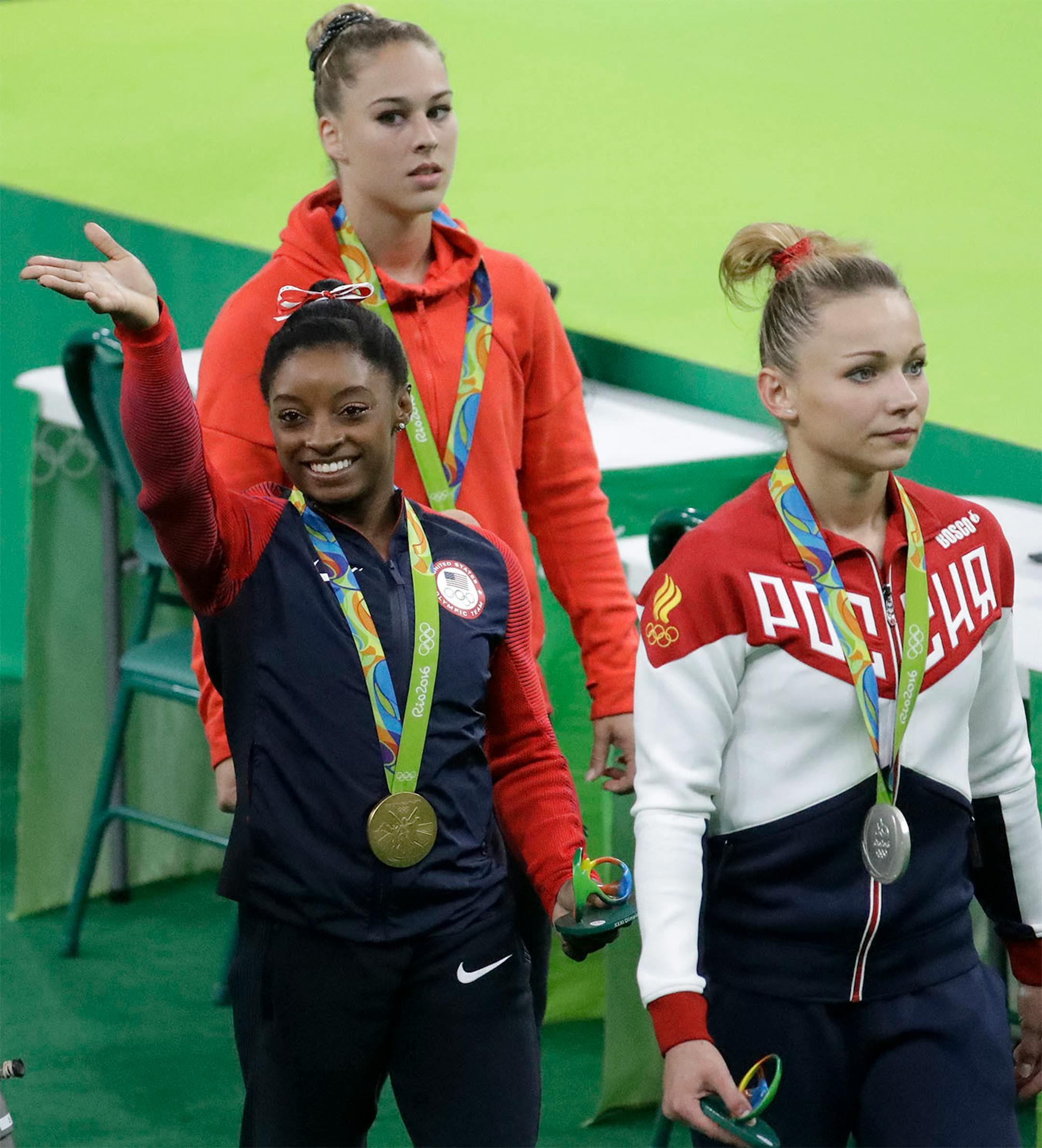 United States' Simone Biles, gold medal winner for vault, waves to the audience as she walks with silver medallist Russia's Maria Paseka, front, and Switzerland's Giulia Steingruber, bronze, during the artistic gymnastics women's apparatus final at the 2016 Summer Olympics in Rio de Janeiro, Brazil, Sunday, Aug. 14, 2016.