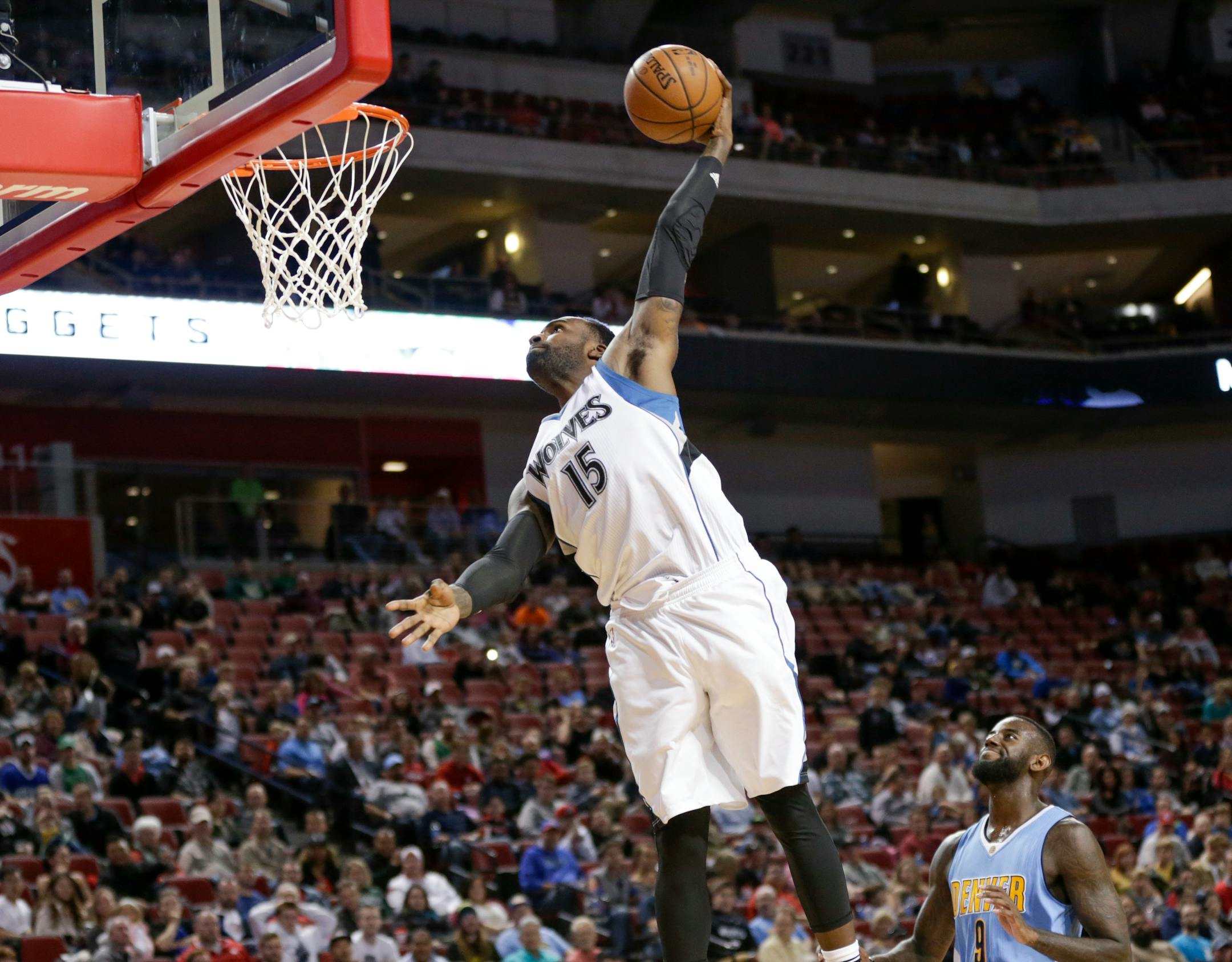 Minnesota Timberwolves center Shabazz Muhammad (15) goes up for a dunk past Denver Nuggets guard JaKarr Sampson (9) during the second half of an NBA preseason basketball game in Lincoln, Neb., Wednesday, Oct. 12, 2016. The Timberwolves won 105-88. (AP Photo/Nati Harnik)