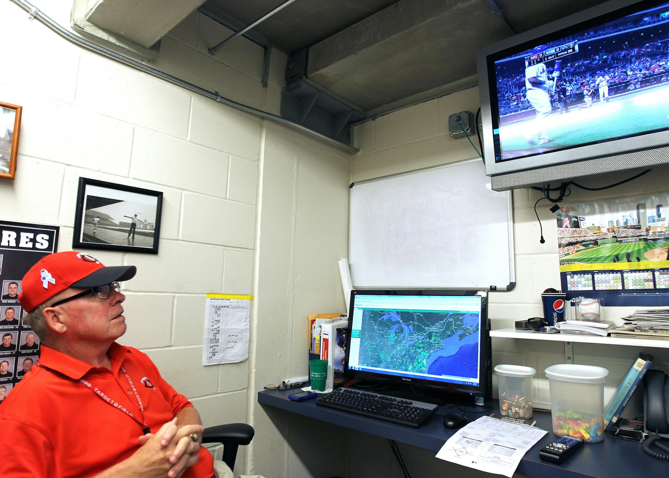 Minnesota Twins game day meteorologist Craig Edwards watches the game and radar in a small room behind the visitor dugout during the Yankees vs. Twins game at Target Field in Minneapolis, Minn., on Tuesday, July 2, 2013. ] (ANNA REED/STAR TRIBUNE) anna.reed@startribune.com (cq)
