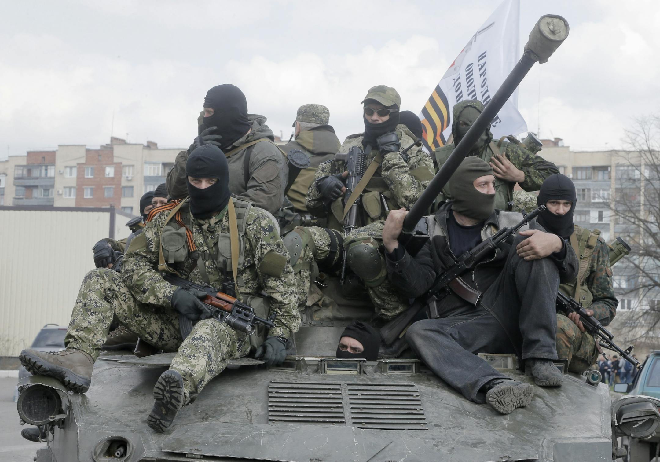 A combat vehicle with pro-Russian gunman on top drives through Slovyansk Wednesday, April 16, 2014. The troops on those vehicles wore green camouflage uniforms, had automatic weapons and grenade launchers and at least one had the St. George ribbon attached to his uniform, which has become a symbol of the pro-Russian insurgency in eastern Ukraine.