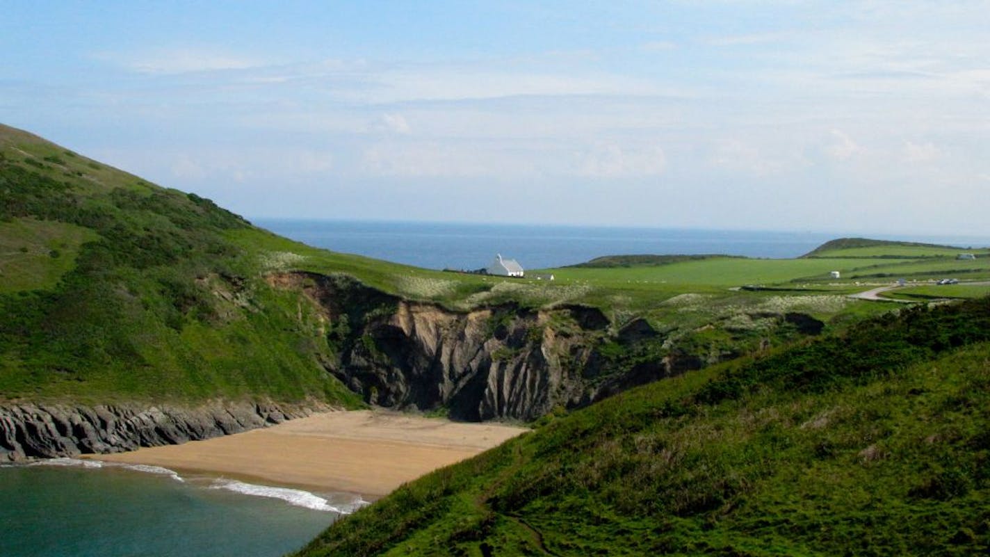 The Wales Coast Path runs past the tiny Church of the Holy Cross in Mwnt. The ancient bright-white Celtic church for sailors can be seen for quite a distance from its perch on the coastline.