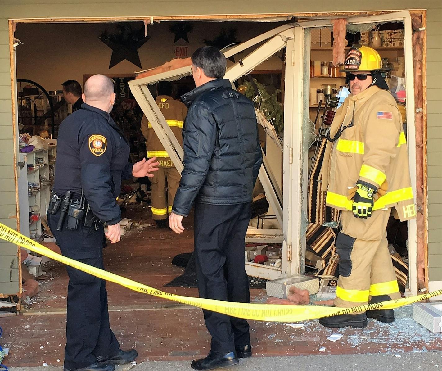 Emergency personnel assessed the scene Saturday morning after a car was driven into the front of a store in downtown Excelsior. Two people inside the store were hurt.