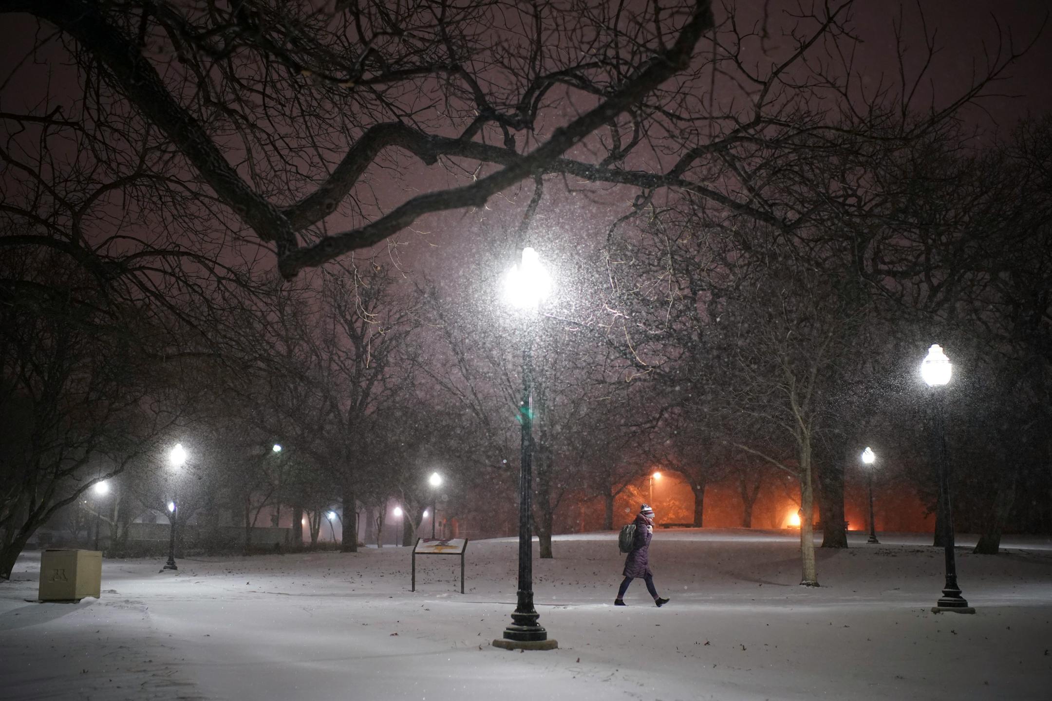 Pedestrians walked across the snowy University of Minnesota campus near Dinkytown Sunday night.