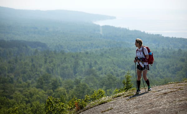 Day-17 - Melanie McManus hikes across the open rock face of Pincushion Mountain near Grand Marais. The outcrop rewards the hiker with spectacular view