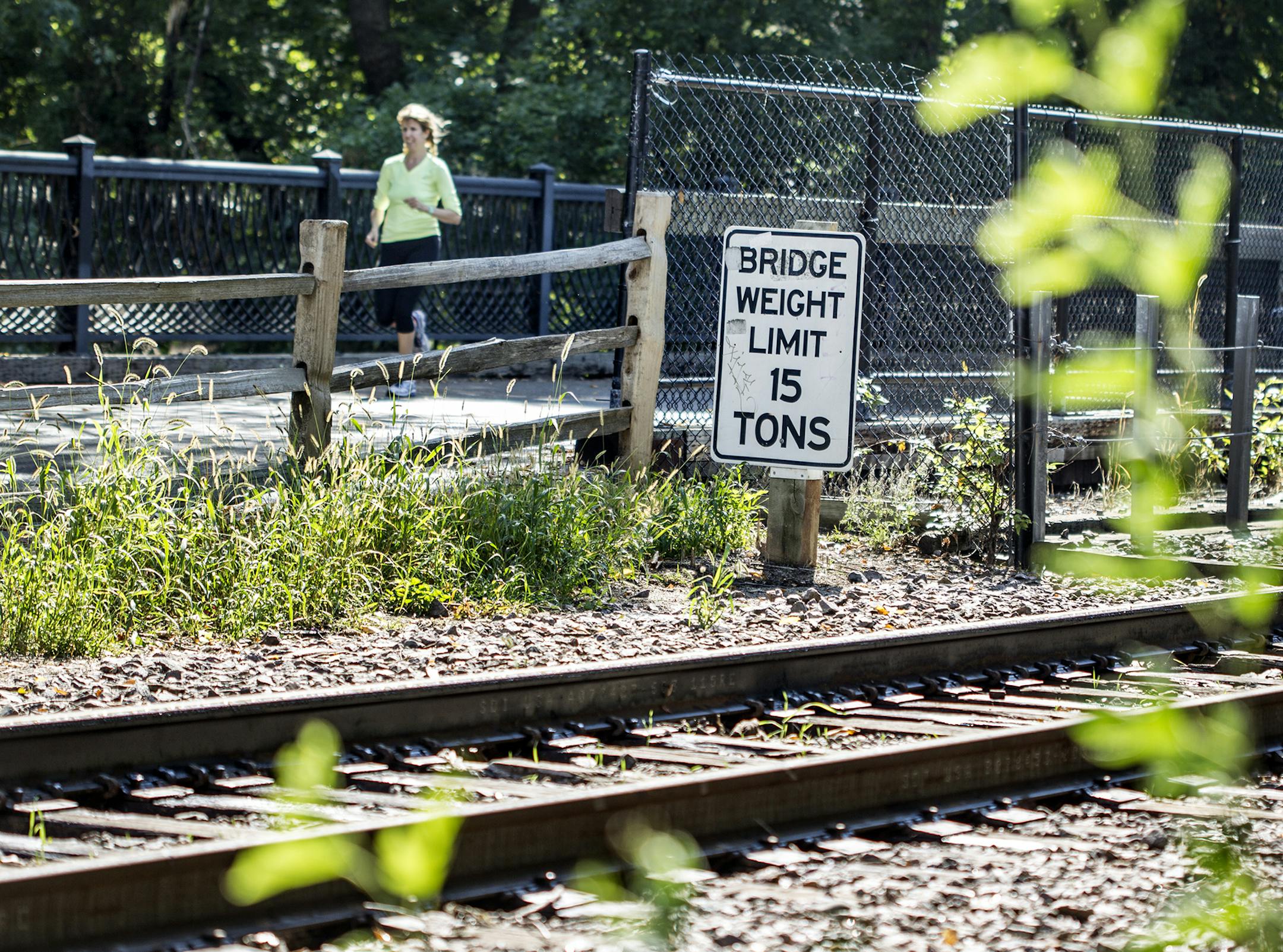 A runner crosses the bridge on Kenilworth Trail that runs parallel to railroad tracks over the channel that runs between Lake of the Isles and Cedar Lake in Minneapolis September 27, 2013. (Courtney Perry/Special to the Star Tribune)