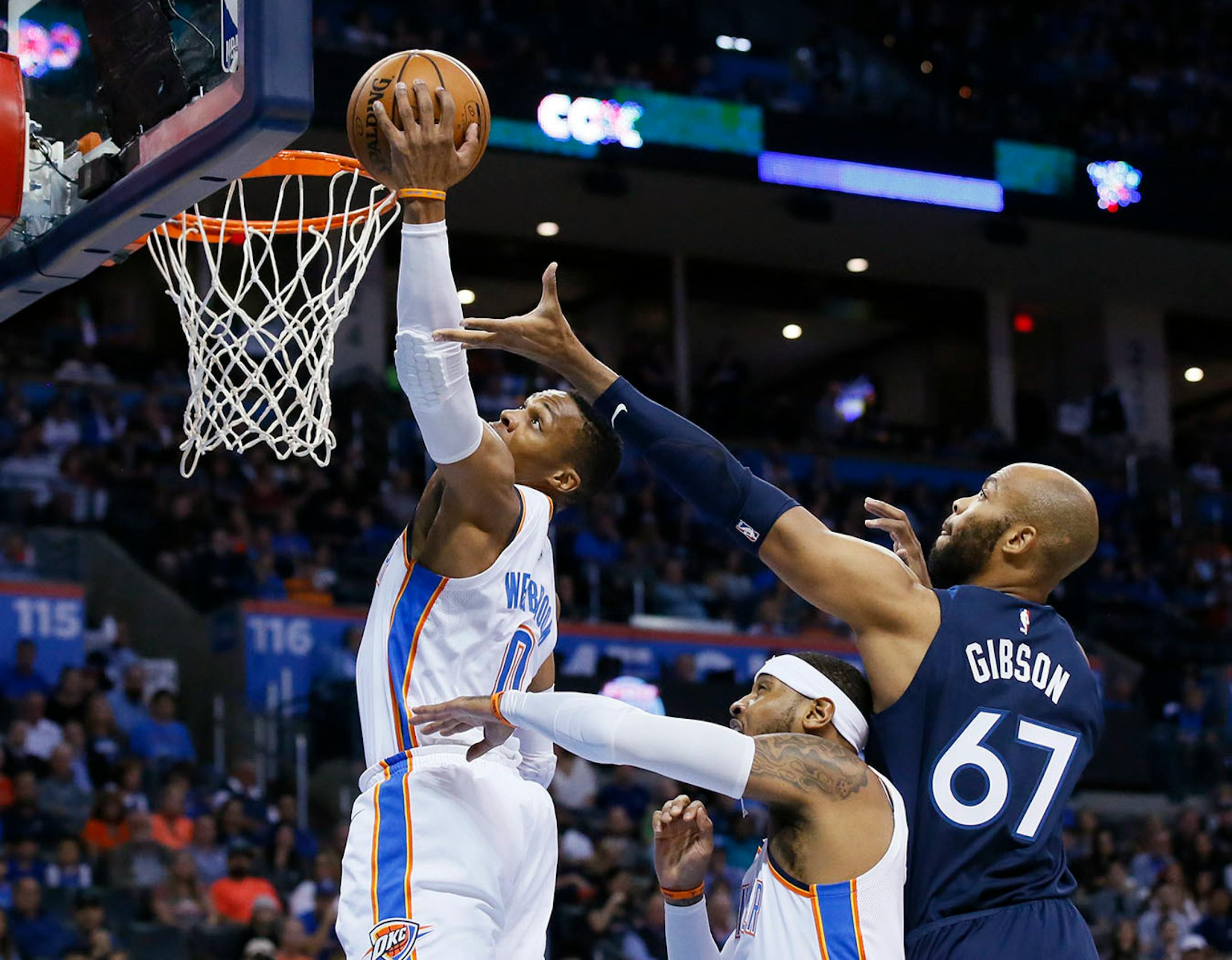 Oklahoma City Thunder guard Russell Westbrook (0) grabs a rebound in front of teammate Carmelo Anthony, center, and Minnesota Timberwolves' Taj Gibson (67) in the first quarter of an NBA basketball game in Oklahoma City, Sunday, Oct. 22, 2017.