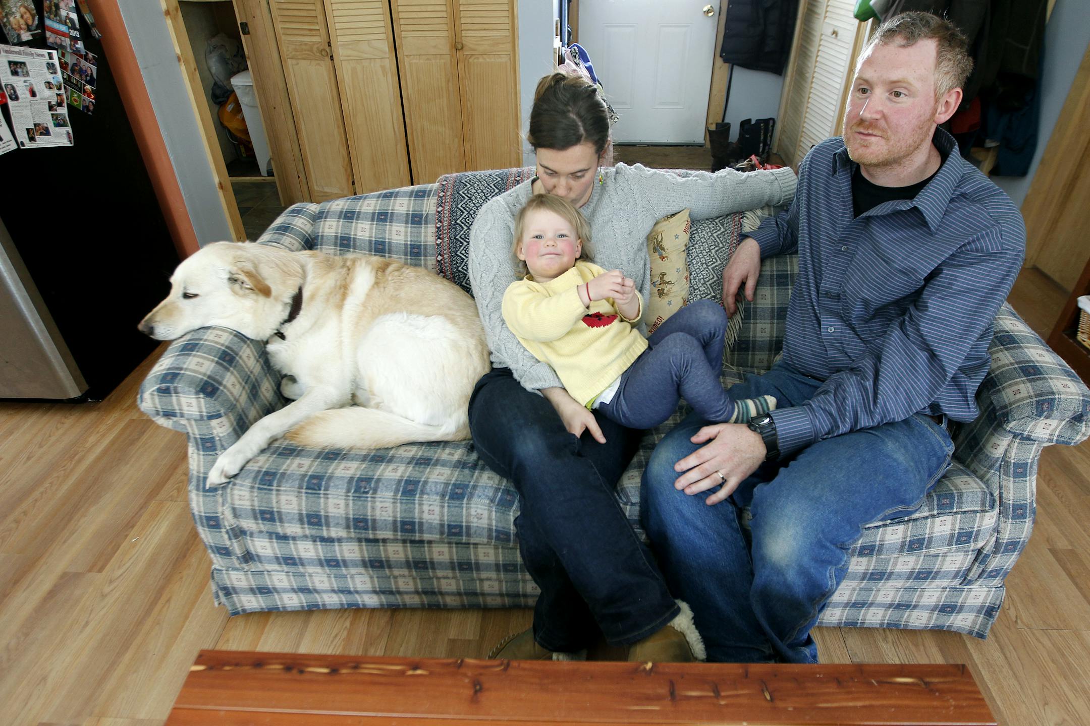 Dave and Amy Demmer, their 2-year-old daughter Penelope, and their dog "Scarlet," hung out on their couch, Saturday, April 26, 2014 in Grand Marais, MN. (ELIZABETH FLORES/STAR TRIBUNE) ELIZABETH FLORES • eflores@startribune.com