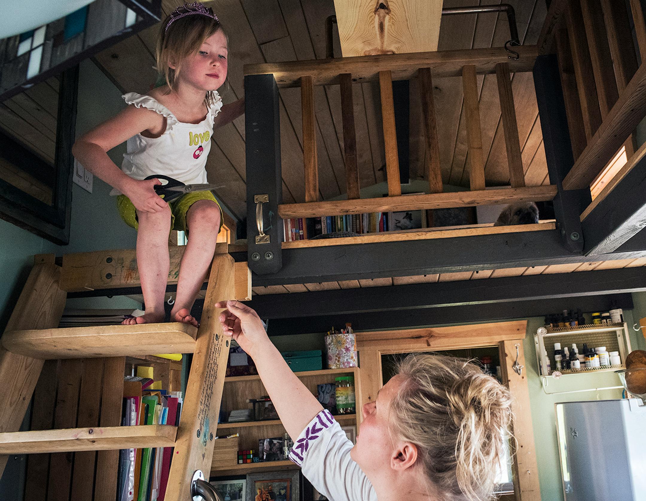 Kim Kasl reaches out to her daughter, Story, on the stairs to the sleeping loft in their tiny house.