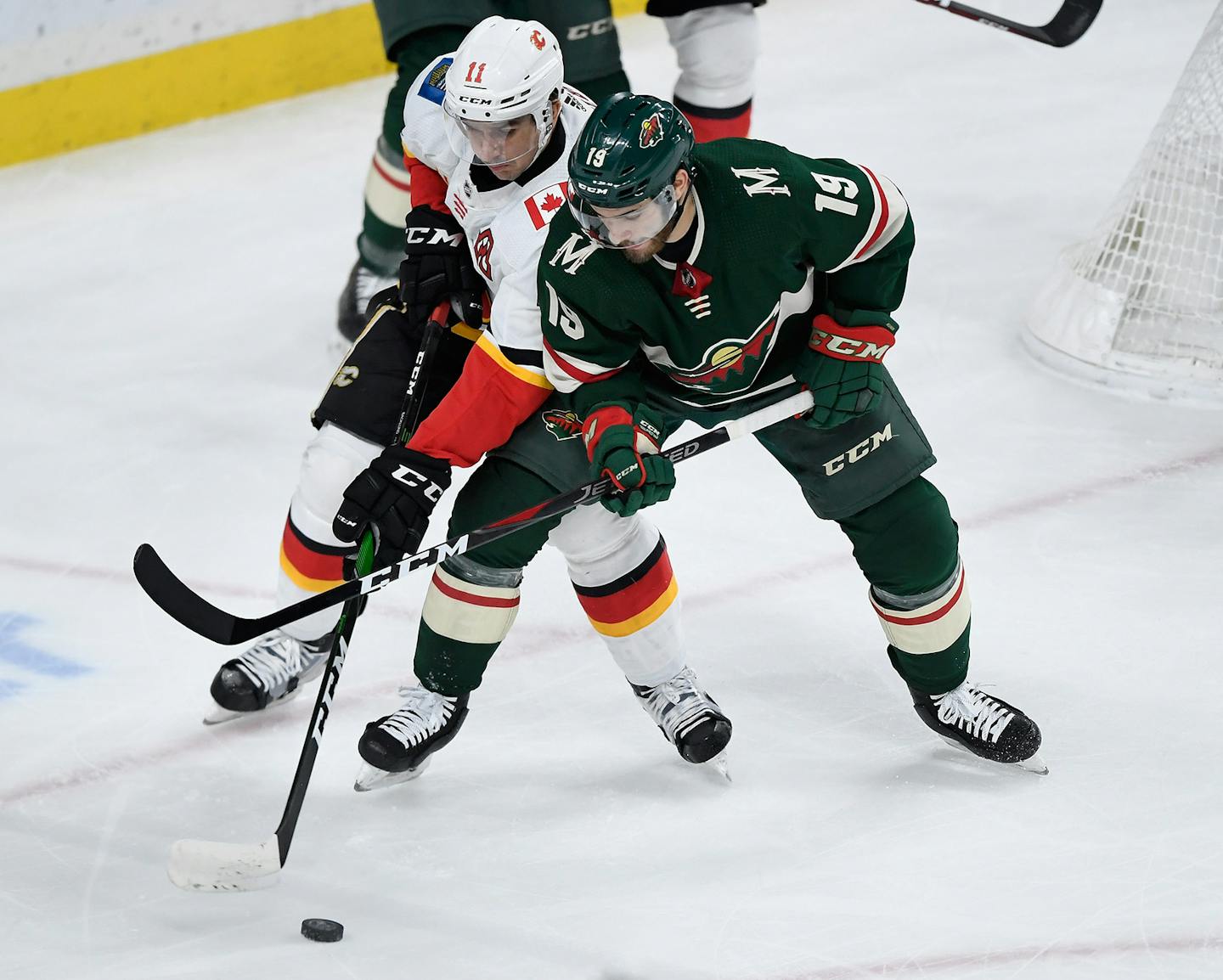 Luke Kunin (19) of the Minnesota Wild keeps Mikael Backlund (11) of the Calgary Flames away from the puck during the first period on Sunday, Jan. 5, 2020 at Xcel Energy Center in St Paul, Minn. (Hannah Foslien/Getty Images/TNS) ORG XMIT: 1533036