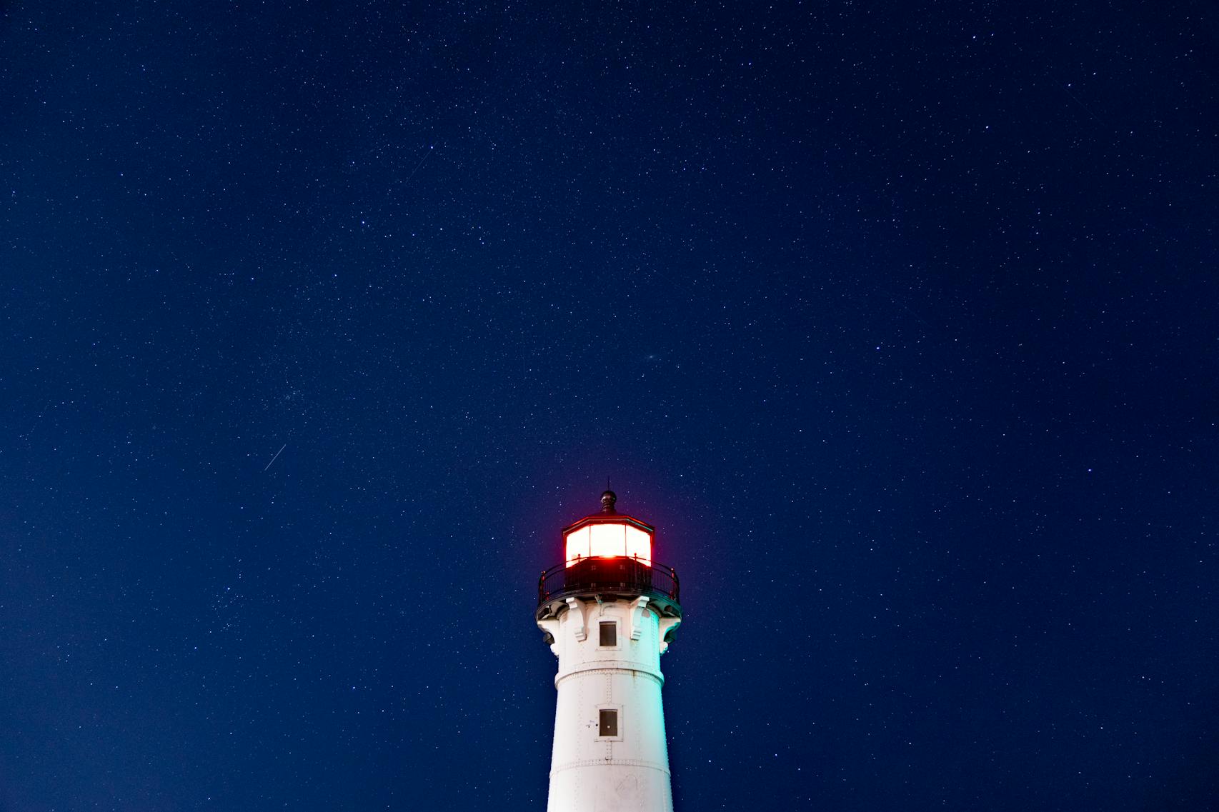 Faint stars are visible over the Duluth Harbor North Breakwater Lighthouse despite light pollution 