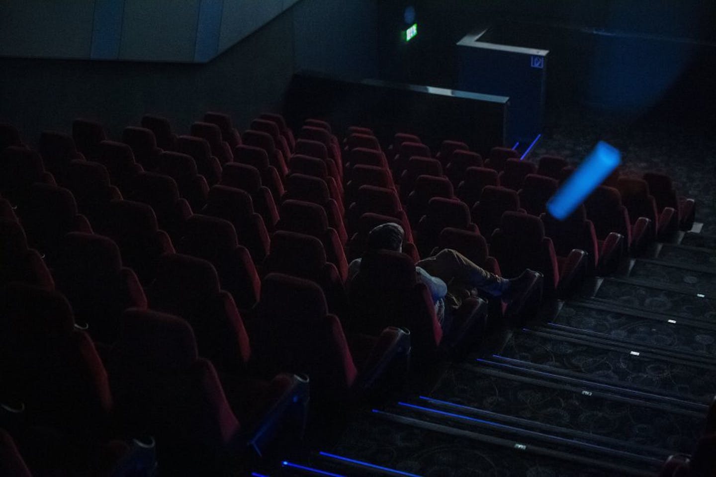 A sole spectator watches a film in a movie theatre in Budapest, Hungary, Thursday, March 12, 2020. Effective from today, cinemas in Hungary are restricted to sell a maximum of 99 tickets for a show as the Hungarian government declared a state of emergency in response to the novel coronavirus, and prohibited all indoor events with more than 100 participants and outdoor events attended by more than 500 participants.