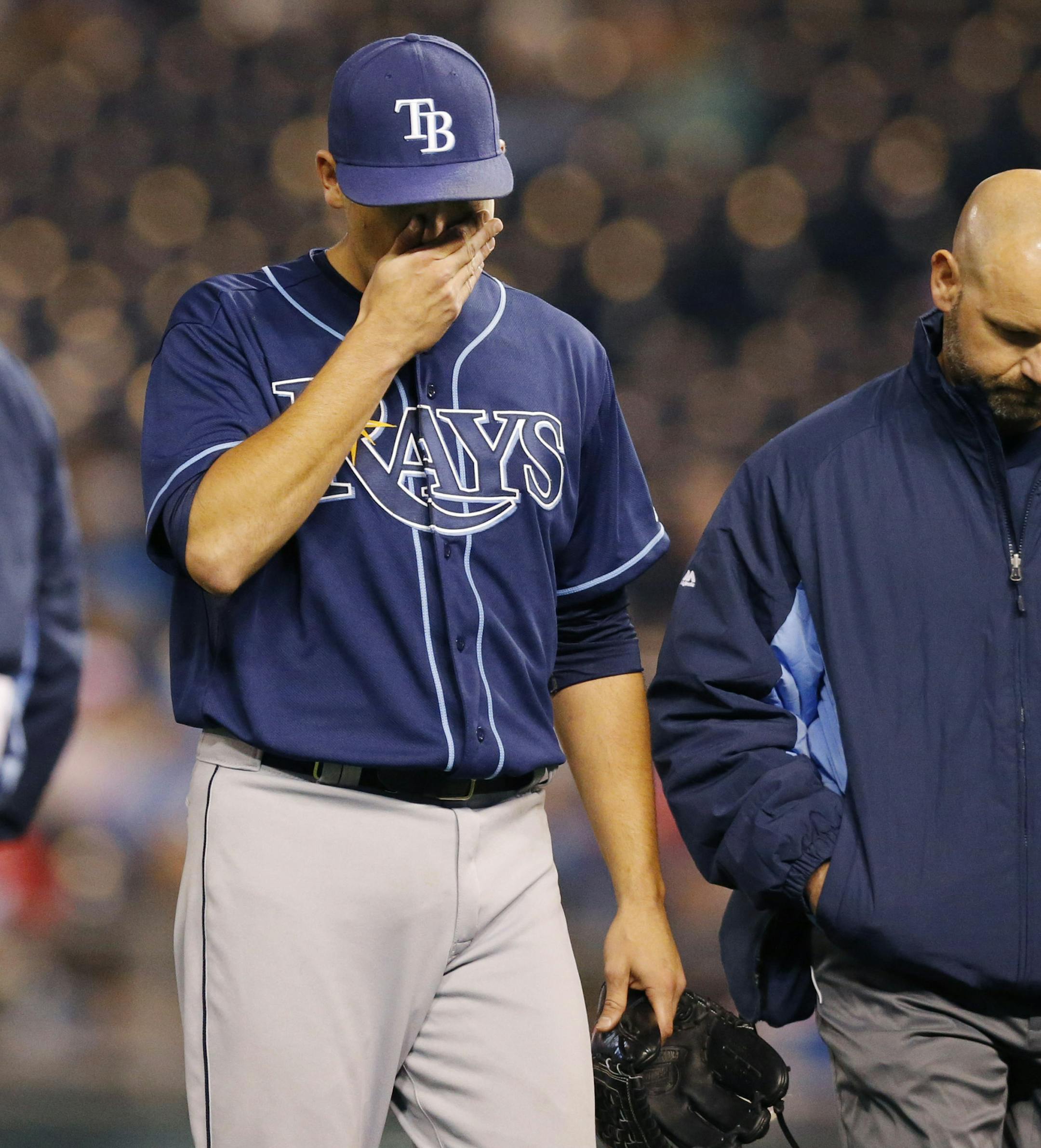 Tampa Bay Rays starting pitcher Matt Moore, left, walks off the field with a trainer following an injury during the sixth inning of the MLB American League baseball game against the Kansas City Royals at Kauffman Stadium in Kansas City, Mo., Monday, April 7, 2014. (AP Photo/Orlin Wagner)
