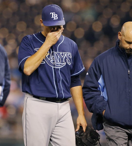 Tampa Bay Rays starting pitcher Matt Moore, left, walks off the field with a trainer following an injury during the sixth inning of the MLB American L