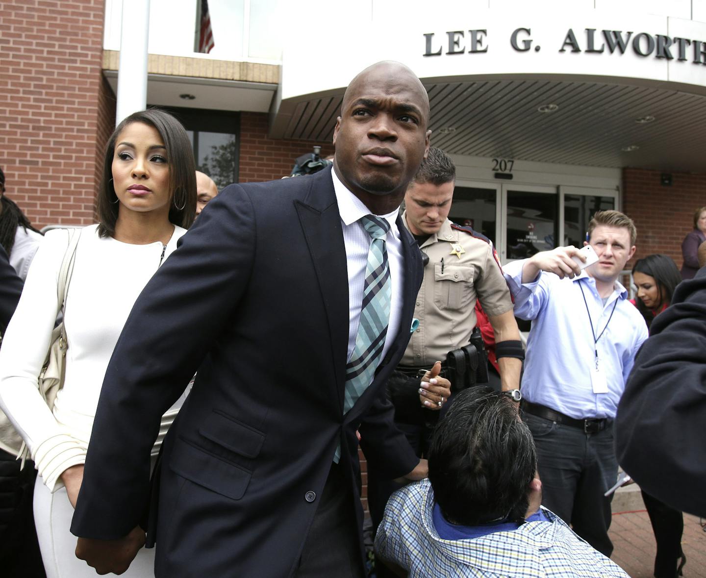 Minnesota Vikings running back Adrian Peterson leaves the courthouse with his wife Ashley Brown Peterson Tuesday, Nov. 4, 2014, in Conroe, Texas. Adrian Peterson avoided jail time on in a plea agreement reached with prosecutors to resolve his child abuse case. (AP Photo/Pat Sullivan) ORG XMIT: TXPS105