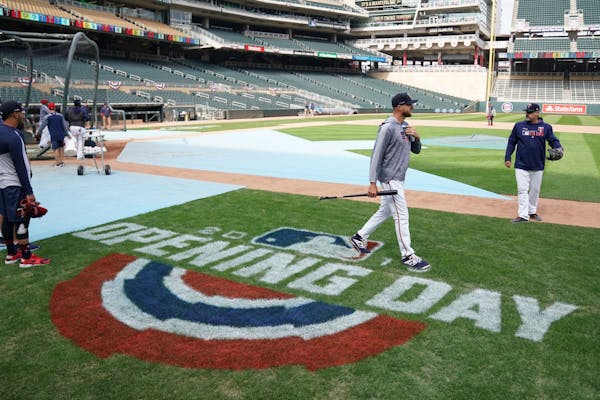 Minnesota Twins manager Rocco Baldelli (5) walked past the Opening Day logo painted on the field during workouts Wednesday.