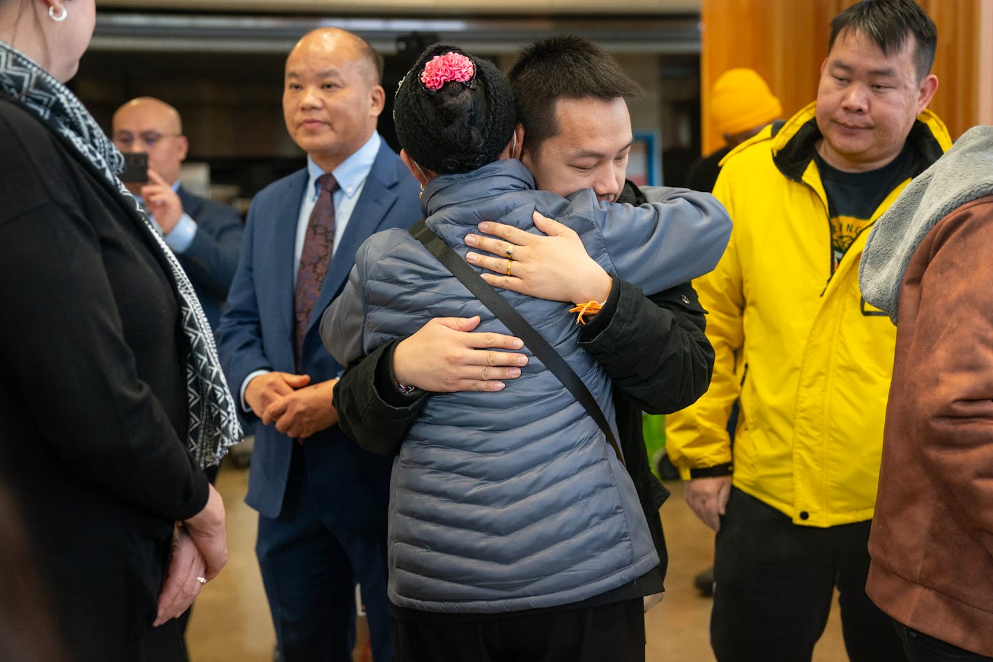 Pa Cheng Vang, the father of four children who died in a house fire on Jan. 3, embraced mourners during a vigil for his family Saturday, Jan. 13, 2024, at American Indian Magnet School in St. Paul, Minn. ]