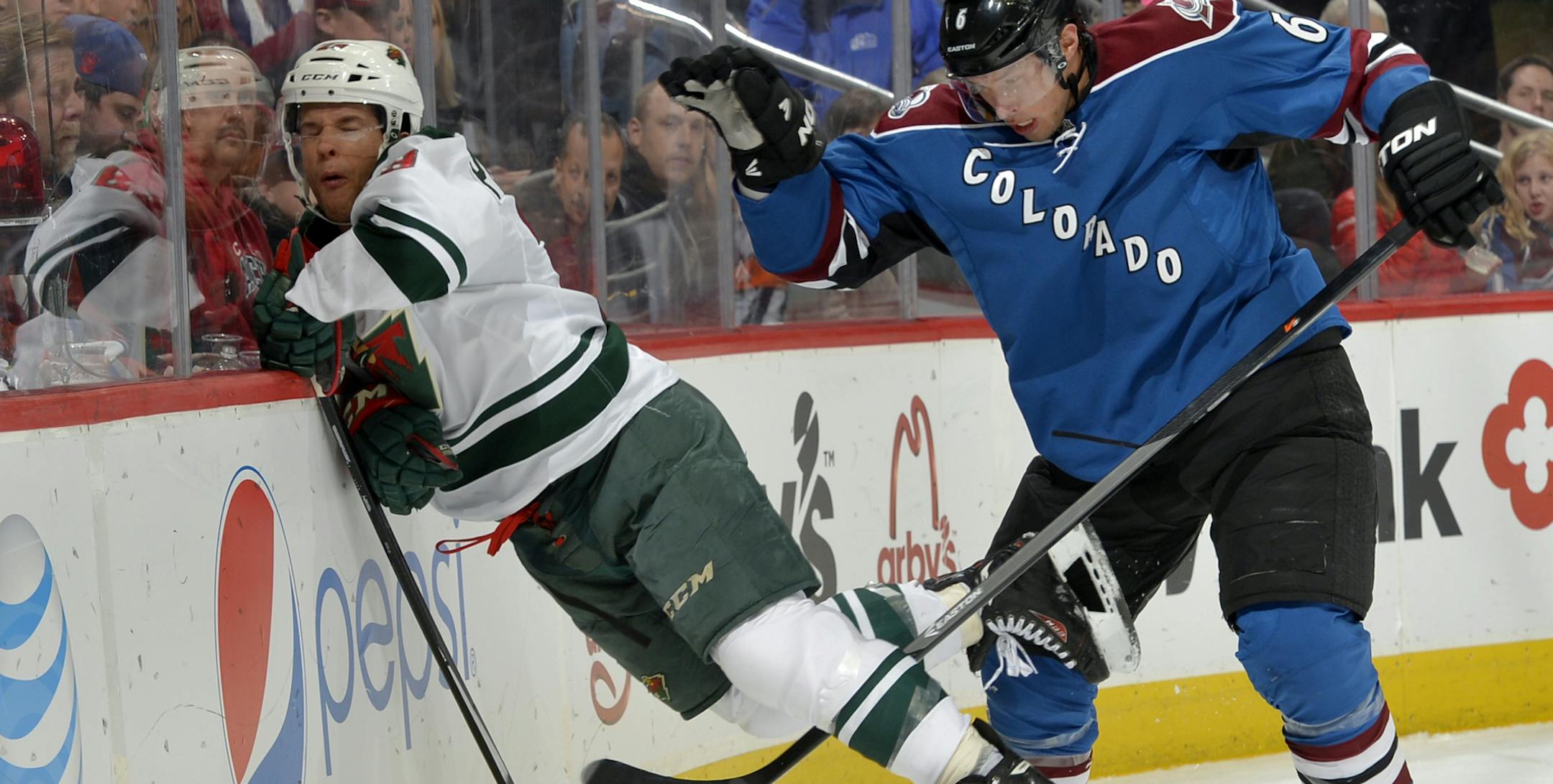 Minnesota Wild right wing Jason Pominville, left, is slammed into the boards by Colorado Avalanche defenseman Erik Johnson (6) during the second period of an NHL hockey game on Saturday, Nov. 30, 2013, in Denver. (AP Photo/Jack Dempsey)