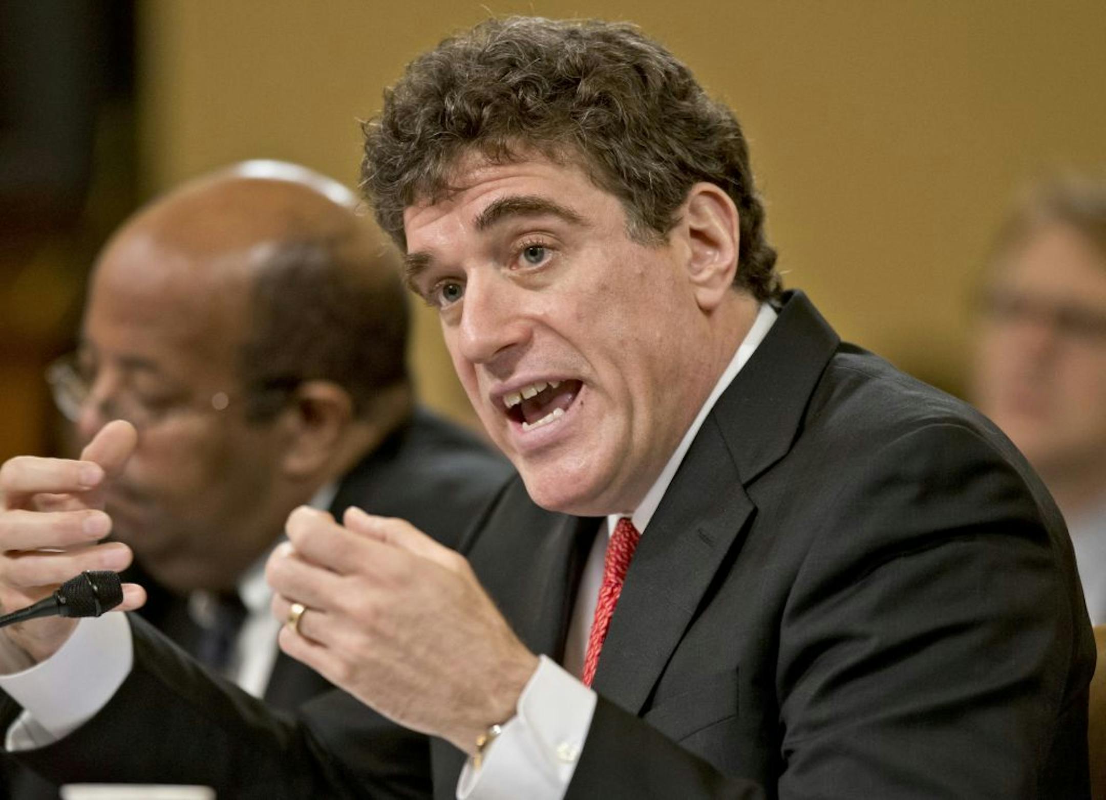 Ousted IRS chief Steven Miller, right, testifies on Capitol Hill in Washington, Friday, May 17,2013, before the House Ways and Means Committee hearing on the extra scrutiny the IRS gave Tea Party and other conservative groups that applied for tax-exempt status. At left is J. Russell George, the Treasury inspector general for tax administration.