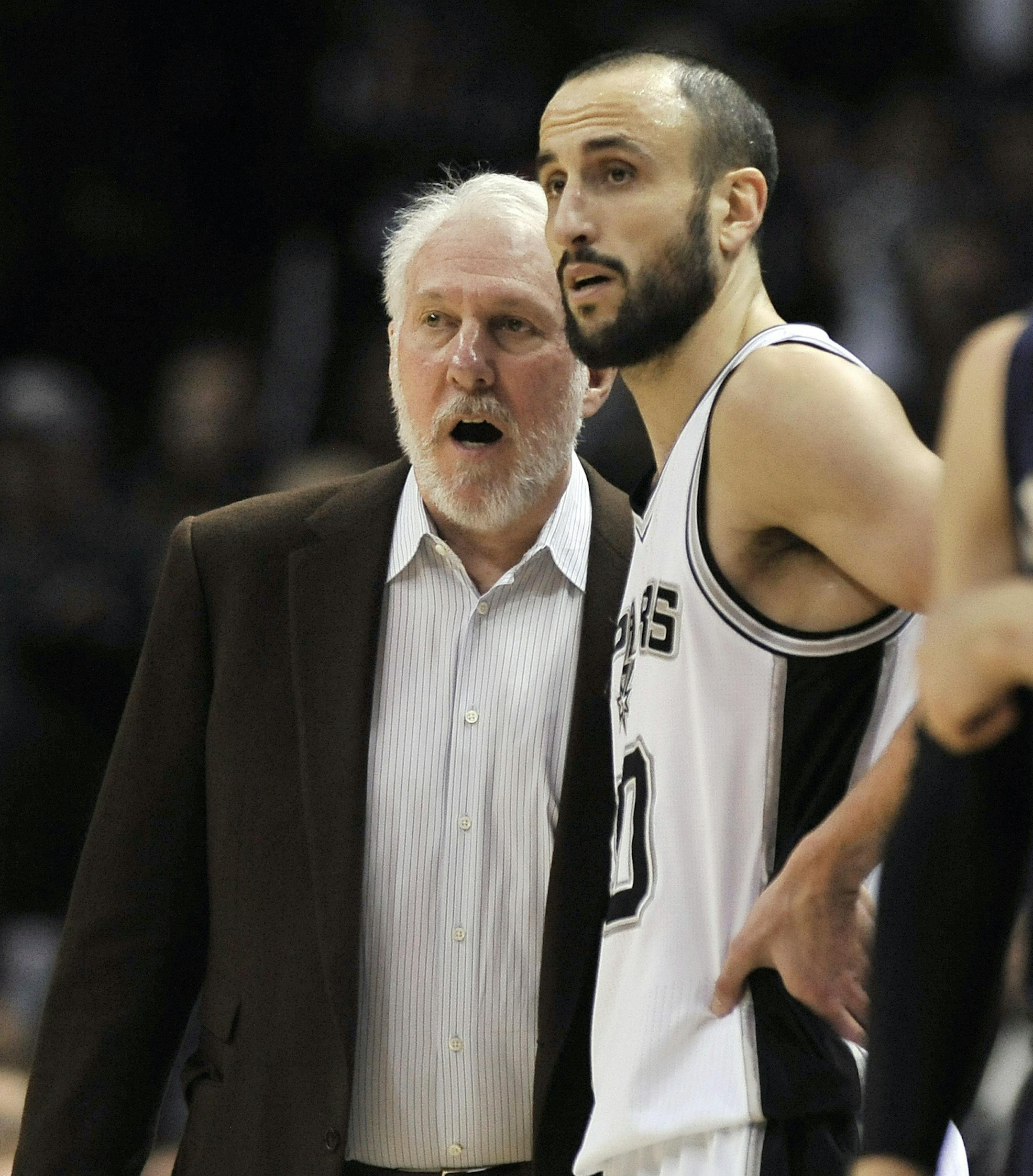 San Antonio Spurs head coach Gregg Popovich, left, speaks with Spurs guard Manu Ginobili in the second half of an NBA basketball game against the New Orleans Pelicans, Wednesday, Dec. 31, 2014, in San Antonio. San Antonio won 95-93 in overtime. (AP Photo/Darren Abate)
