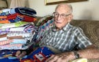 Jack Morrow, 95, sat with a few of the 500 blankets he's made for the charity Bundles of Love over the past seven years.