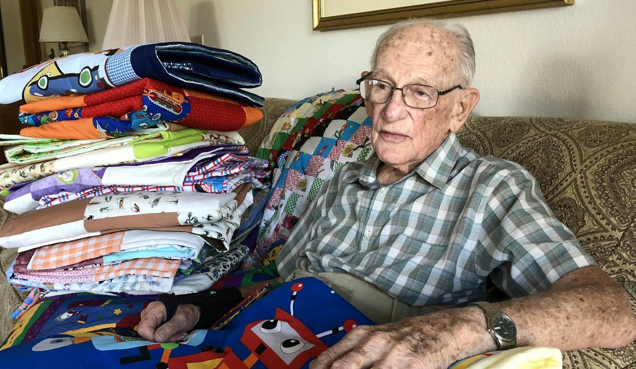 Jack Morrow, 95, sat with a few of the 500 blankets he's made for the charity Bundles of Love over the past seven years.