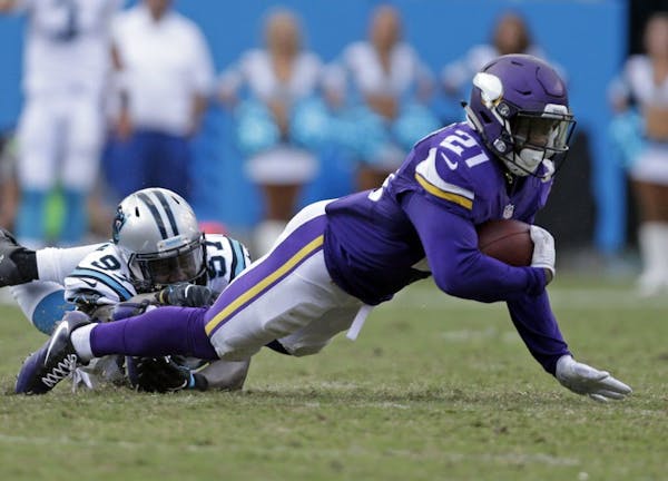 Minnesota Vikings' Jerick McKinnon (21) is tackled by Carolina Panthers' Mario Addison (97) in the second half of an NFL football game in Charlotte, N