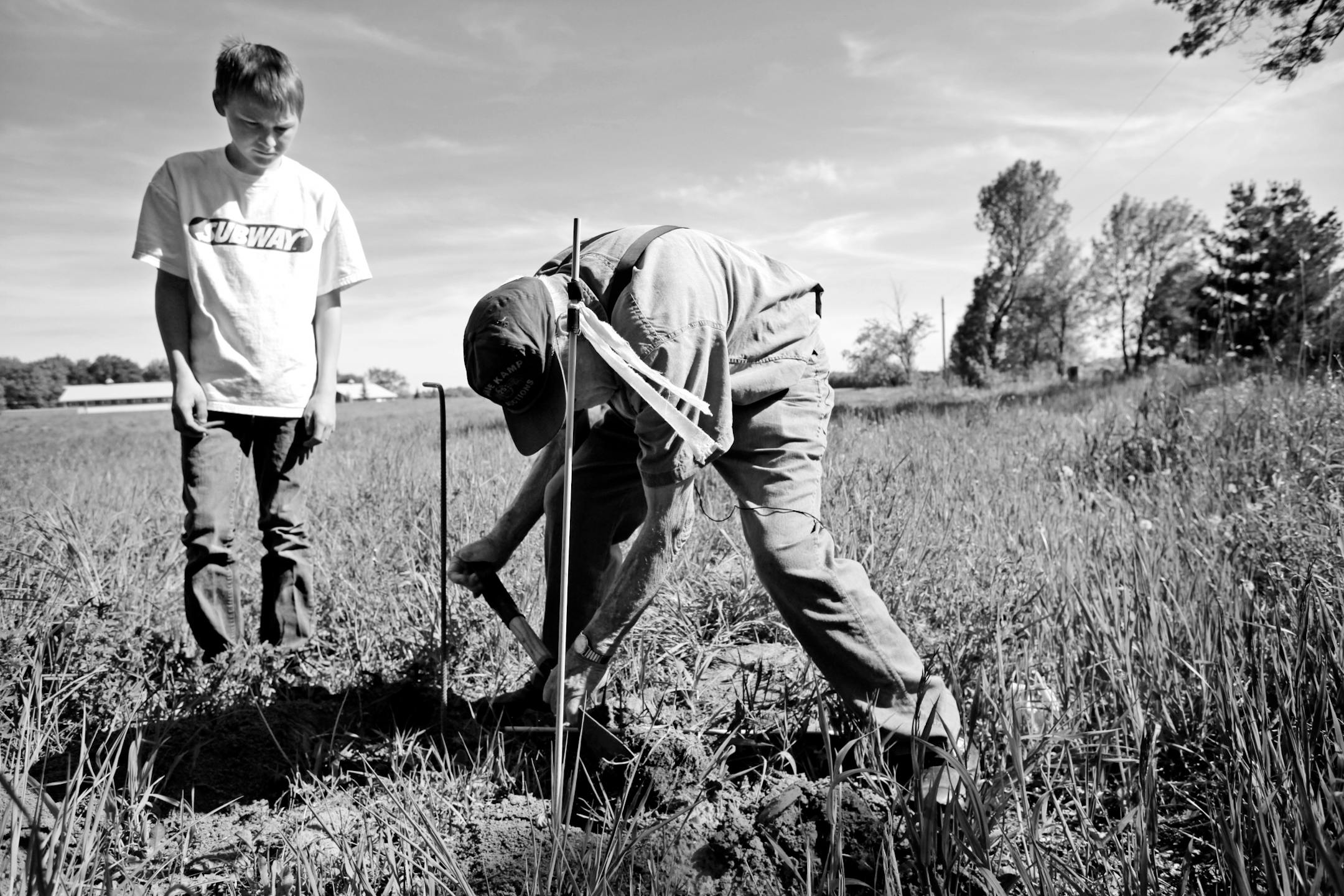 Merila watches as Arkman digs for the gopher tunnel before setting a gopher trap.
