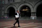 A man carried printed copies of a redacted version of the special counsel's report as he walked past the Trump International Hotel in Washington on Th