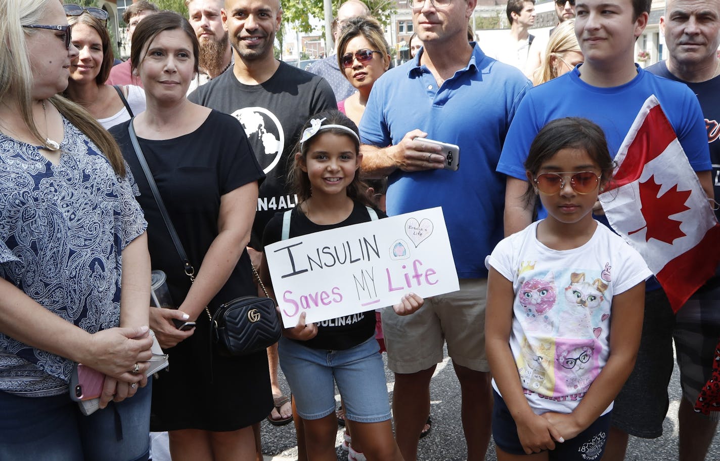 Clara Whited, 8, of LaSalle, Ont., waits for Democratic presidential candidate, Sen. Bernie Sanders, I-Vt. outside the Olde Walkersville Pharmacy, Sunday, July 28, 2019, in Windsor, Ont. Sanders and a busload of insulin patients stopped in Windsor to purchase the drug to highlight the high costs of the insulin in the United States. (AP Photo/Carlos Osorio)