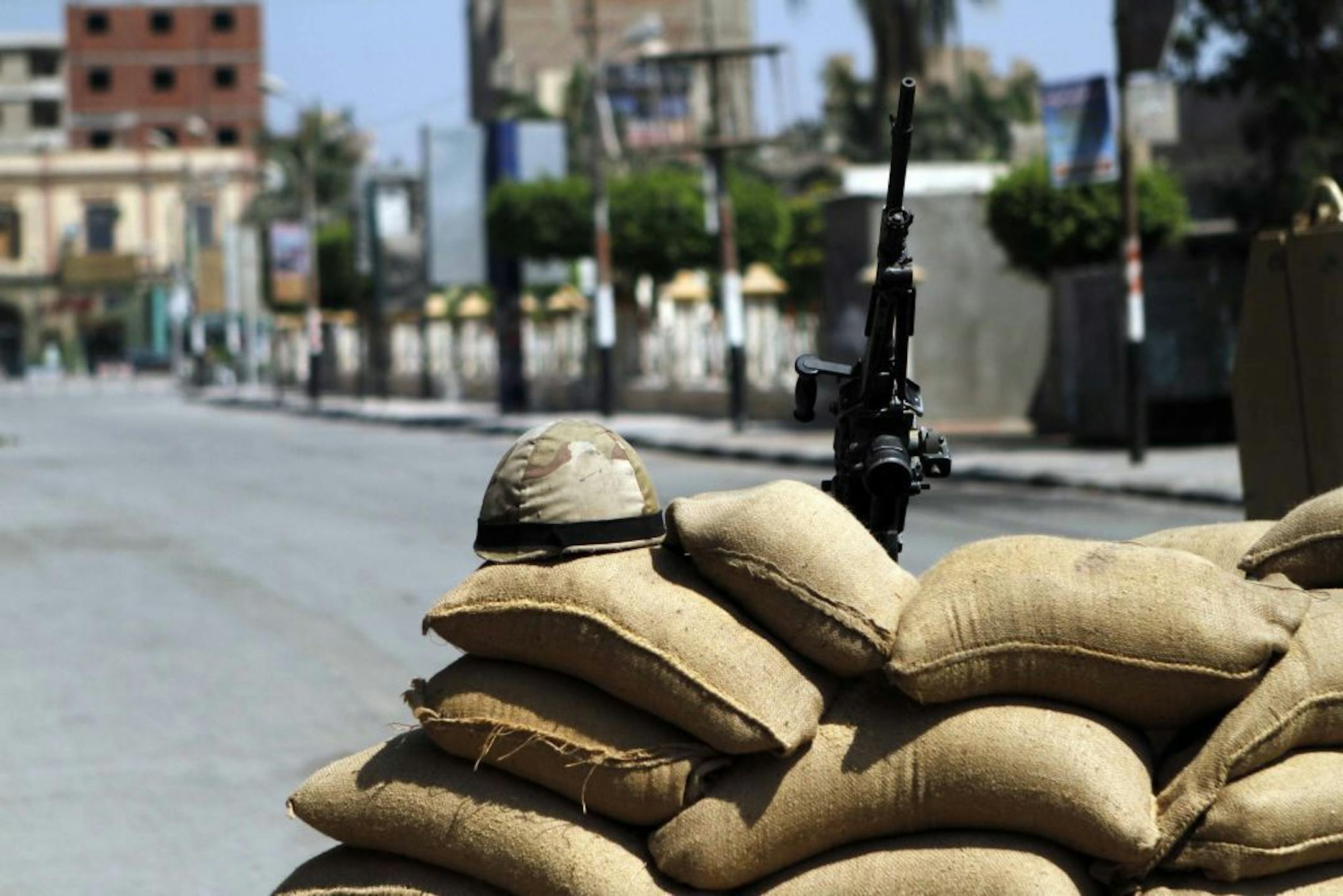 A helmet and a weapon of the Egyptian security forces are placed at a barricade as they prepare to watch the area in Beni Sueif, south of Cairo, Egypt, Friday, Aug. 30, 2013.