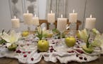 Jeralyn Mohr of Full Nest's holiday centerpiece includes apples, cranberries, limes, carrot tops, flowers and candles displayed on upside-down glasswa