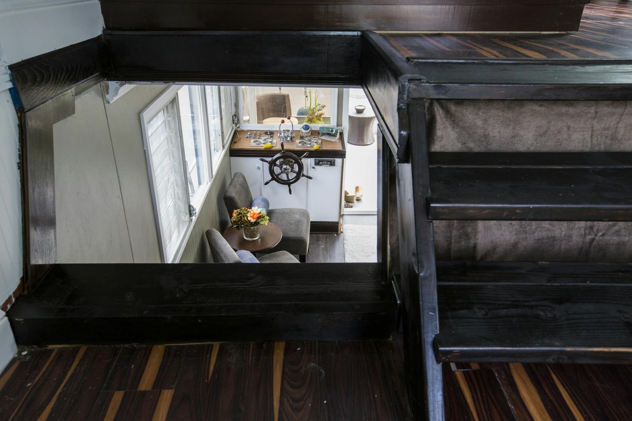 The stairs leading down from the houseboat's upper floor.