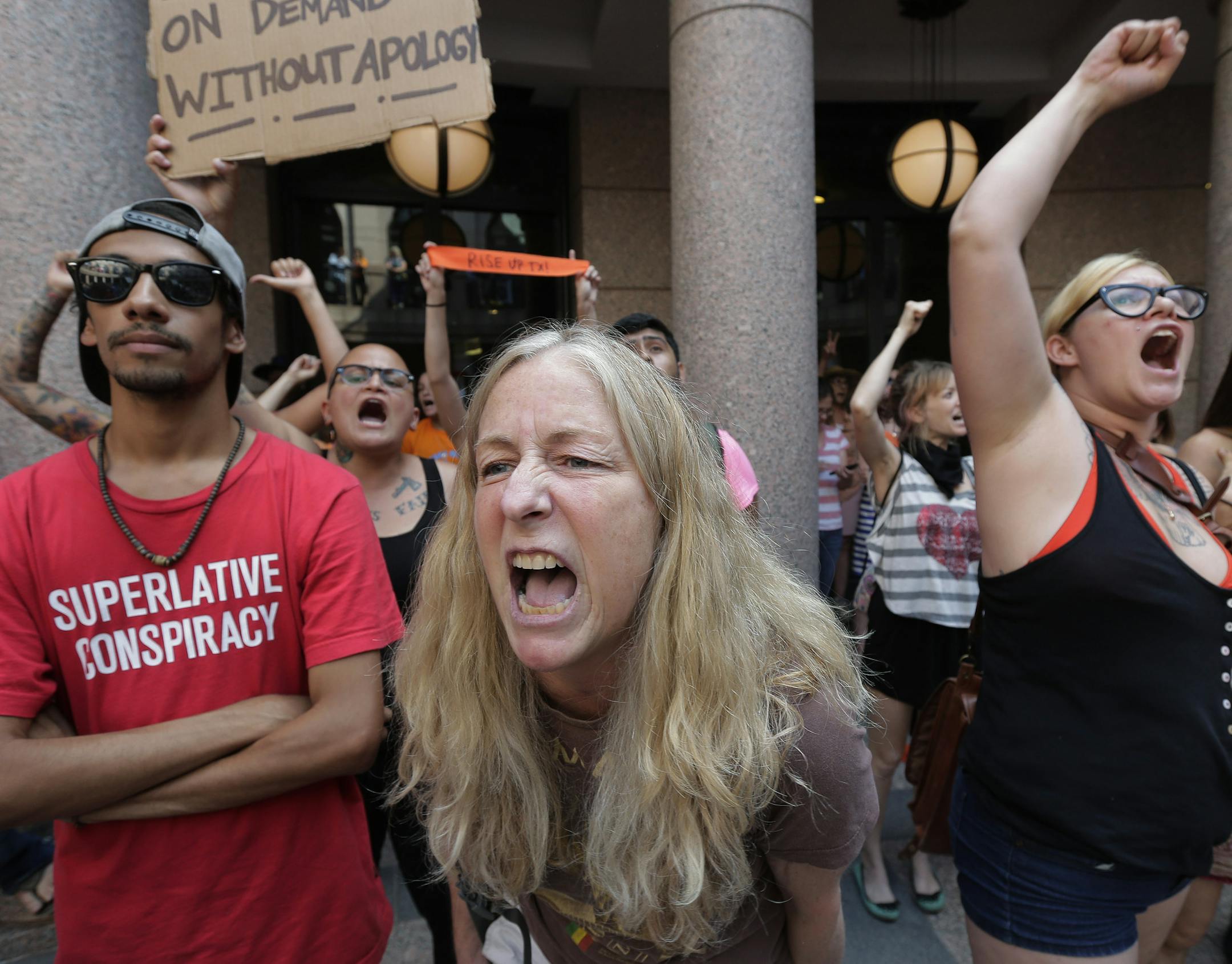 Opponents of an abortion bill, including a woman who gave her name as Wendy, center, and Jessica Deleskey, right, yell chants outside a hearing for the bill at the state capitol, Tuesday, July 2, 2013, in Austin, Texas. Gov. Rick Perry has called lawmakers back for another special session with abortion on the top of the agenda. (AP Photo/Eric Gay)