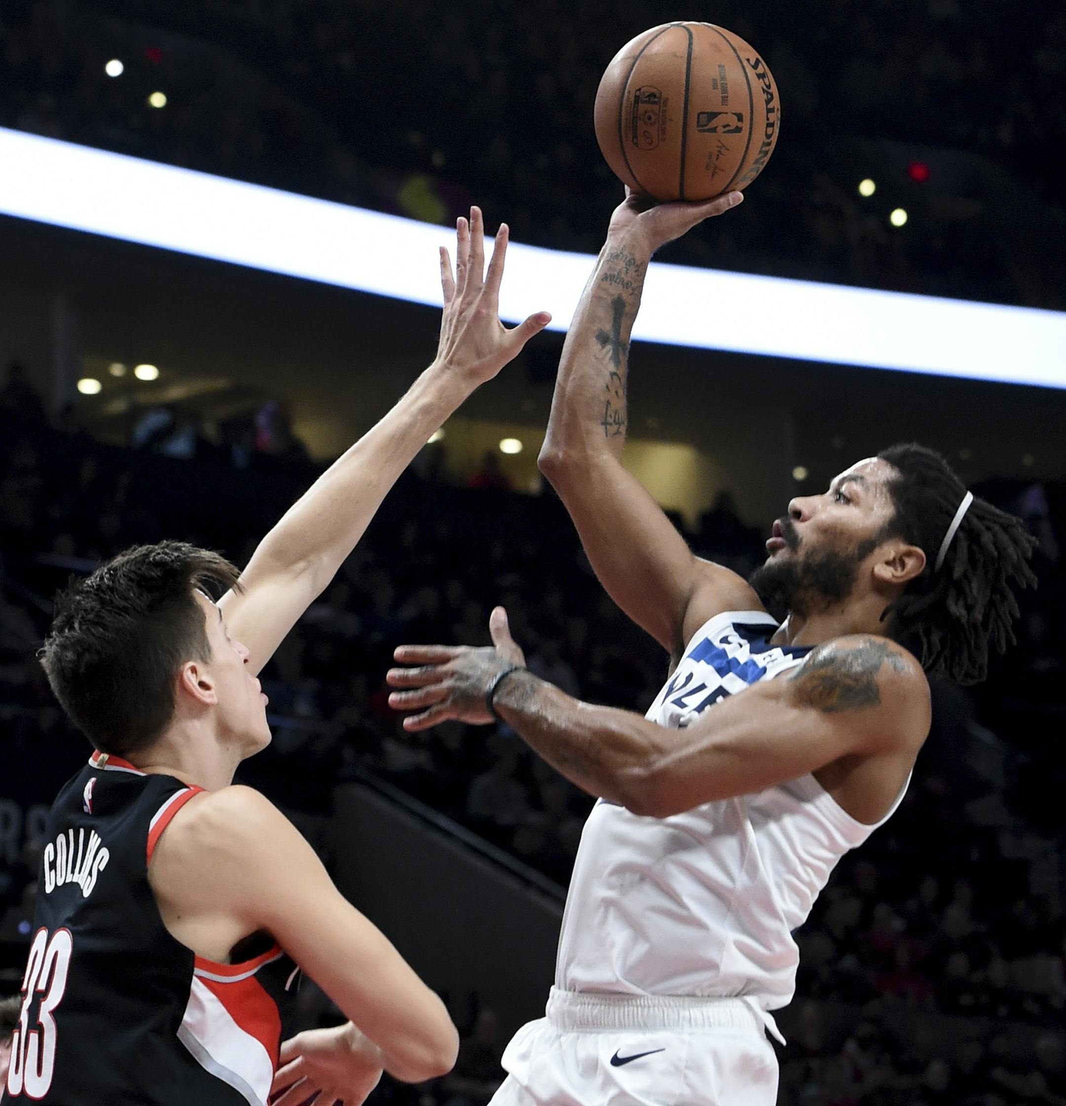 Minnesota Timberwolves guard Derrick Rose, right, shoots over Portland Trail Blazers forward Zach Collins during the first half of an NBA basketball game in Portland, Ore., Saturday, Dec. 8, 2018. (AP Photo/Steve Dykes)