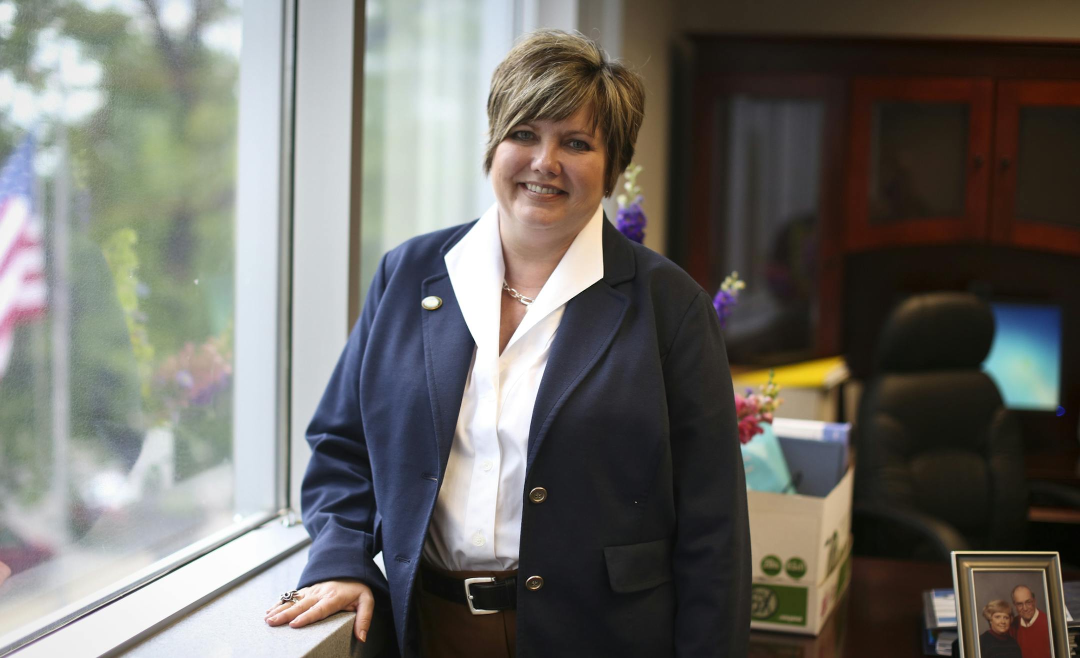 Denise Specht, the new president of Education Minnesota, stood in her new office on her second day of work in St. Paul, Minn. on Tuesday, July 9, 2013. On her desk were boxes to unload and a picture of her parents who were both teachers. ] (RENEE JONES SCHNEIDER * reneejones@startribune.com)