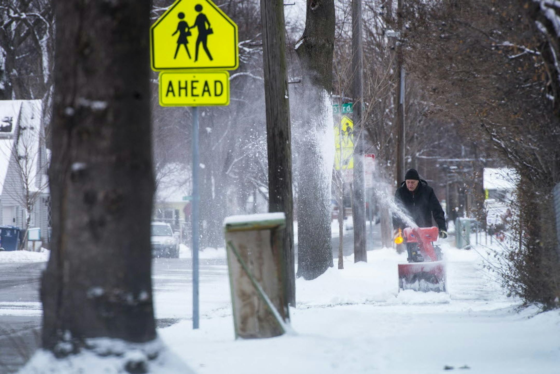 Gerald Ellendson used a snow blower to clear snow from the sidewalk alongside his south Minneapolis home on Saturday afternoon.