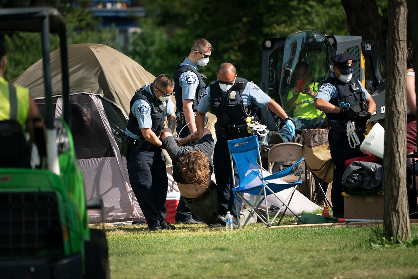 Police dragged a person from a tent as they cleared tents and possessions from the east side homeless encampment at Powderhorn Park in Minneapolis on Monday, July 20, 2020. All but these two tents had been demolished and trashed or packed up and removed by volunteers when police arrested about a dozen people who stood their ground in front of the remaining tents. Those arrested were a combination of volunteers and residents of the camp.