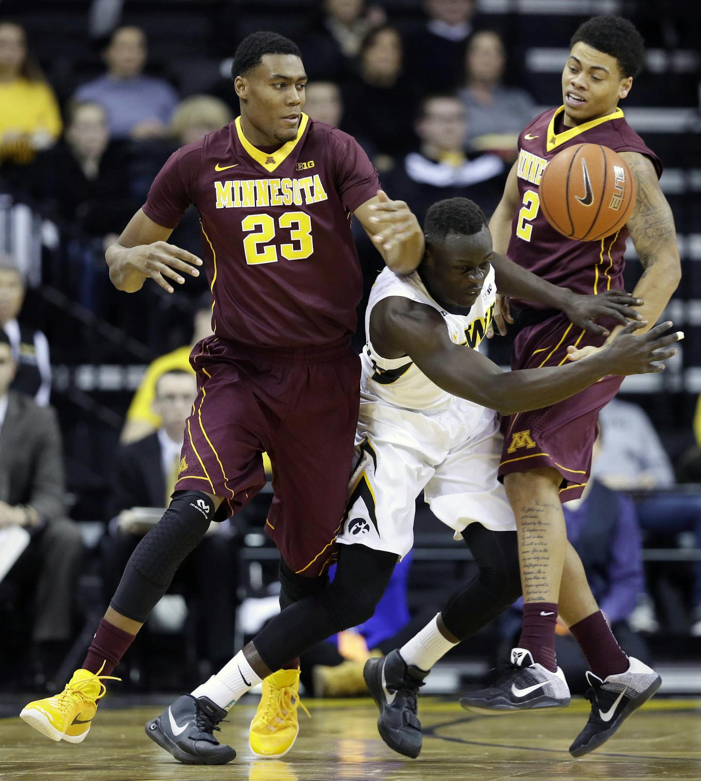 Iowa guard Peter Jok, center, steals the ball between Minnesota's Charles Buggs, left, and Nate Mason, right, during the first half of an NCAA college basketball game, Sunday, Feb. 14, 2016, in Iowa City, Iowa. (AP Photo/Charlie Neibergall)