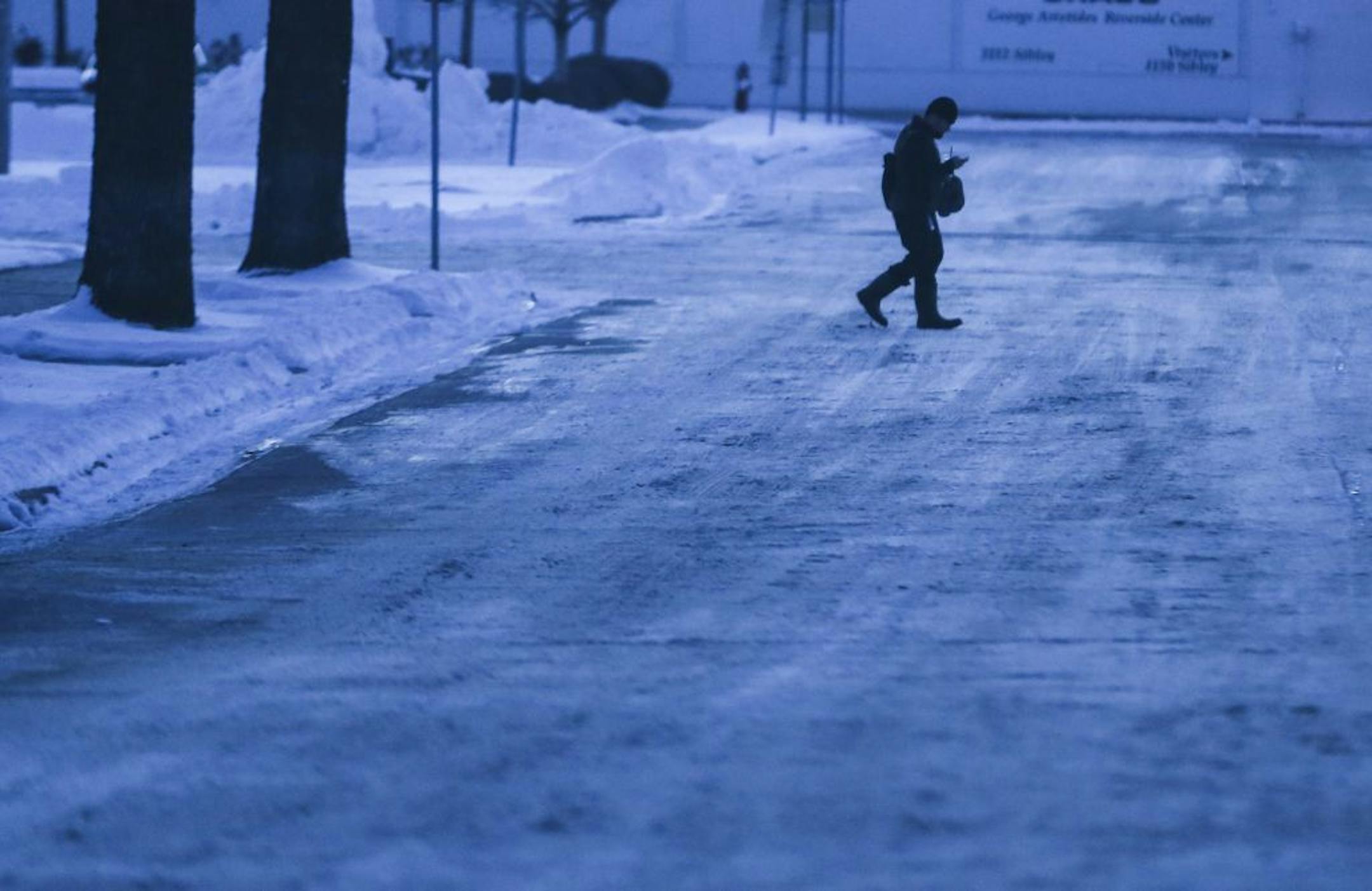 A man walked on a snow-covered street on a chilly Monday evening on December 29, 2014, in Minneapolis, Minn.