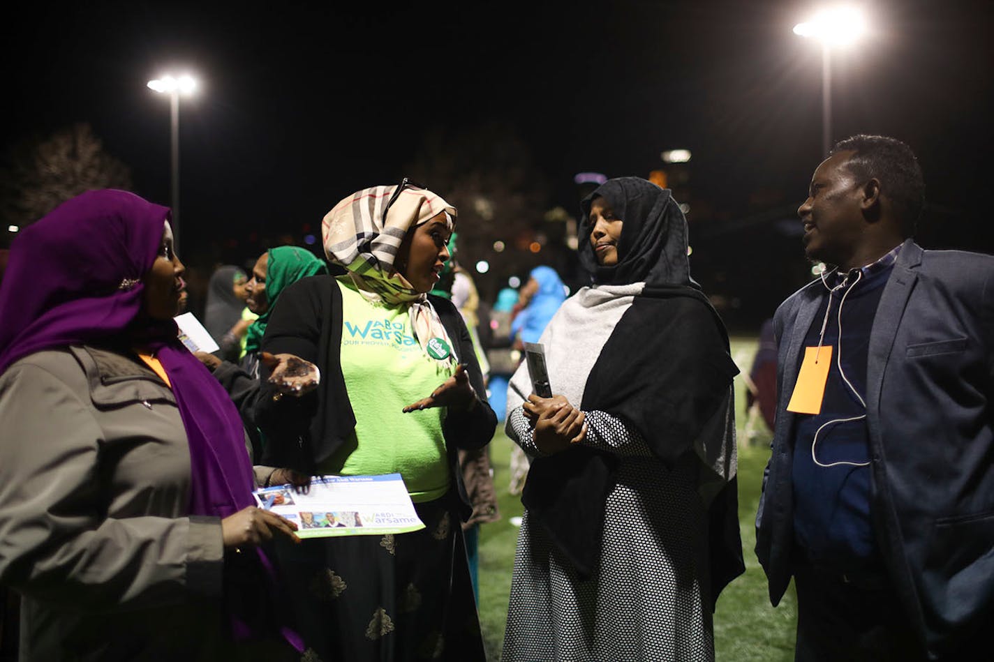 Ayanna Yusef, an Abdi Warsame supporter, in the green t-shirt, explained the caucus results to some others after an official announced the results.