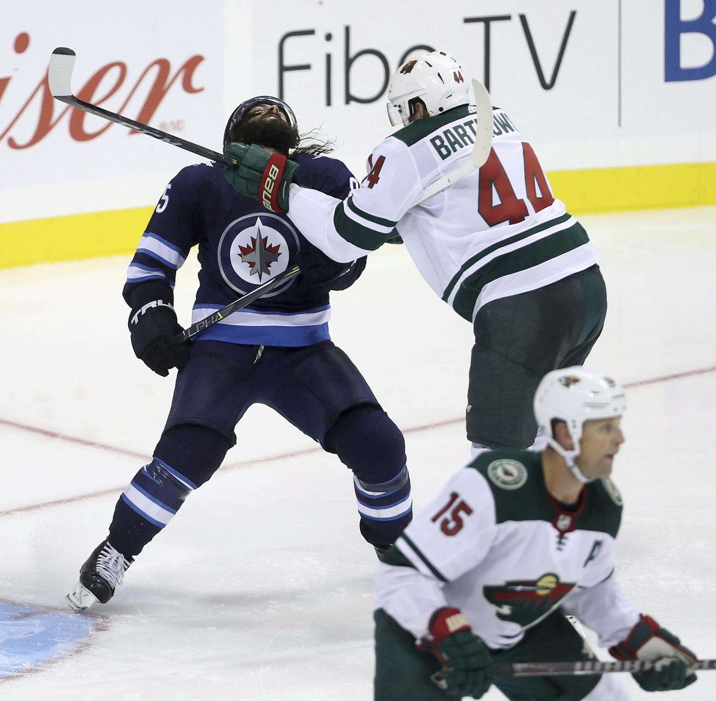 Winnipeg Jets' Mathieu Perreault, left,is cross-checked by Minnesota Wild's Matt Bartkowski (44) during third -period preseason NHL hockey game action in Winnipeg, Manitoba, Monday, Sept. 17, 2018. (Trevor Hagan/The Canadian Press via AP)