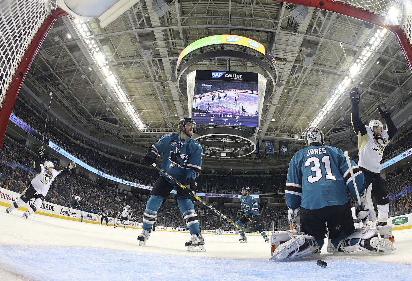 Pittsburgh Penguins center Nick Bonino, right, reacts next to San Jose Sharks goalie Martin Jones (31) and defenseman Paul Martin after Penguins' Brian Dumoulin scored during the first period of Game 6 of the NHL hockey Stanley Cup Finals in San Jose, Calif., Sunday, June 12, 2016. (Bruce Bennett/Getty Images via AP, Pool)