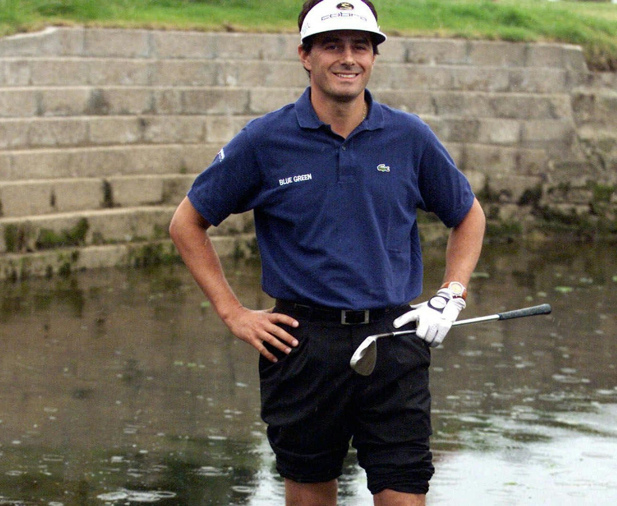 FILE - In this July 18, 1999, file photo, France's Jean Van de Velde smiles as he stands in the water of the Barry Burn that crosses the 18th fairway to see if his ball, bottom center, was playable during the final round of the 128th British Open Golf Championship at Carnoustie, Scotland. Van de Velde went on to make triple bogey and lose the Open in a playoff. (AP Photo/File) UK OUT ORG XMIT: NY160