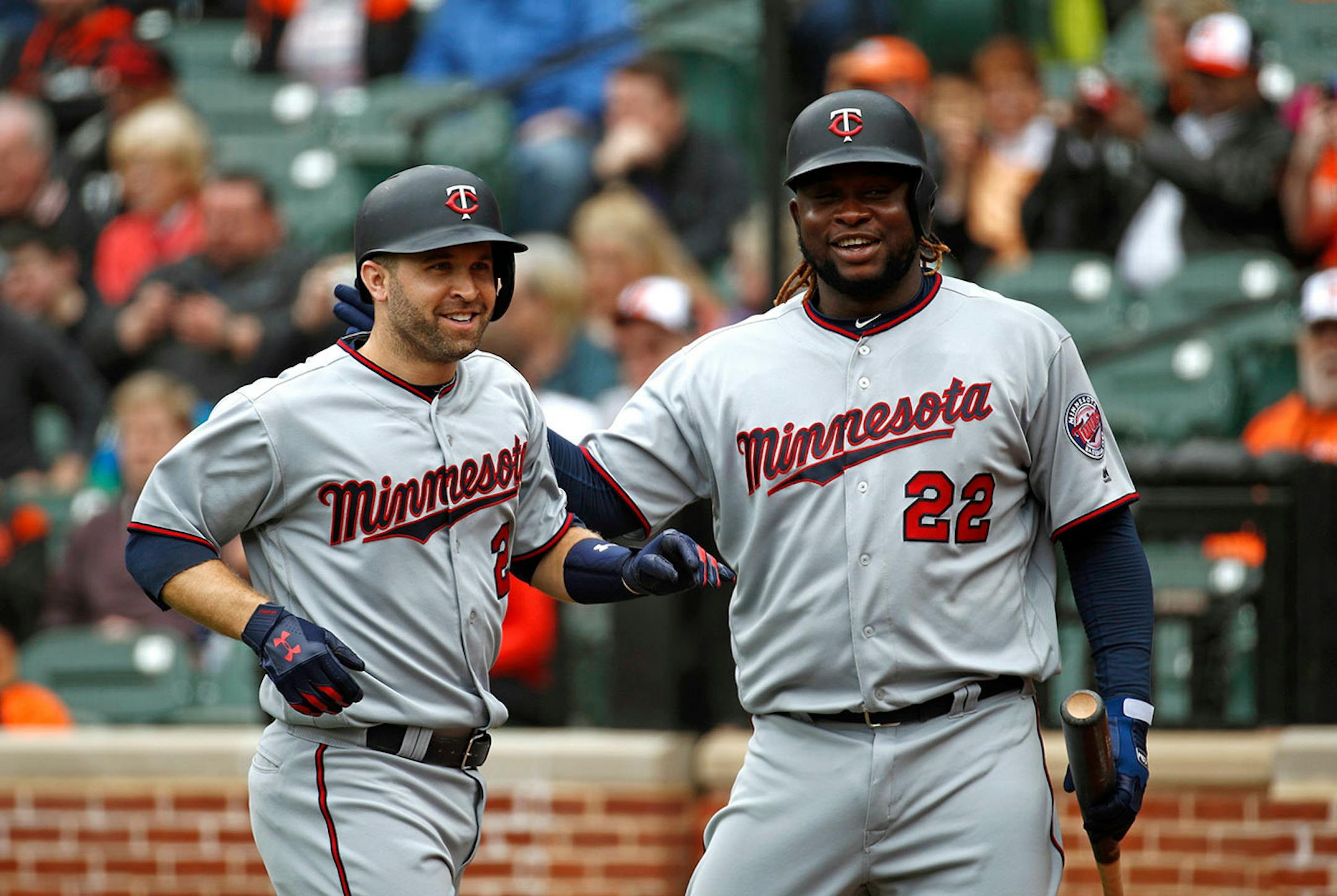 Minnesota Twins' Brian Dozier, left, celebrates his solo home run with teammate Miguel Sano in the first inning of a baseball game against the Baltimore Orioles, Sunday, April 1, 2018, in Baltimore.