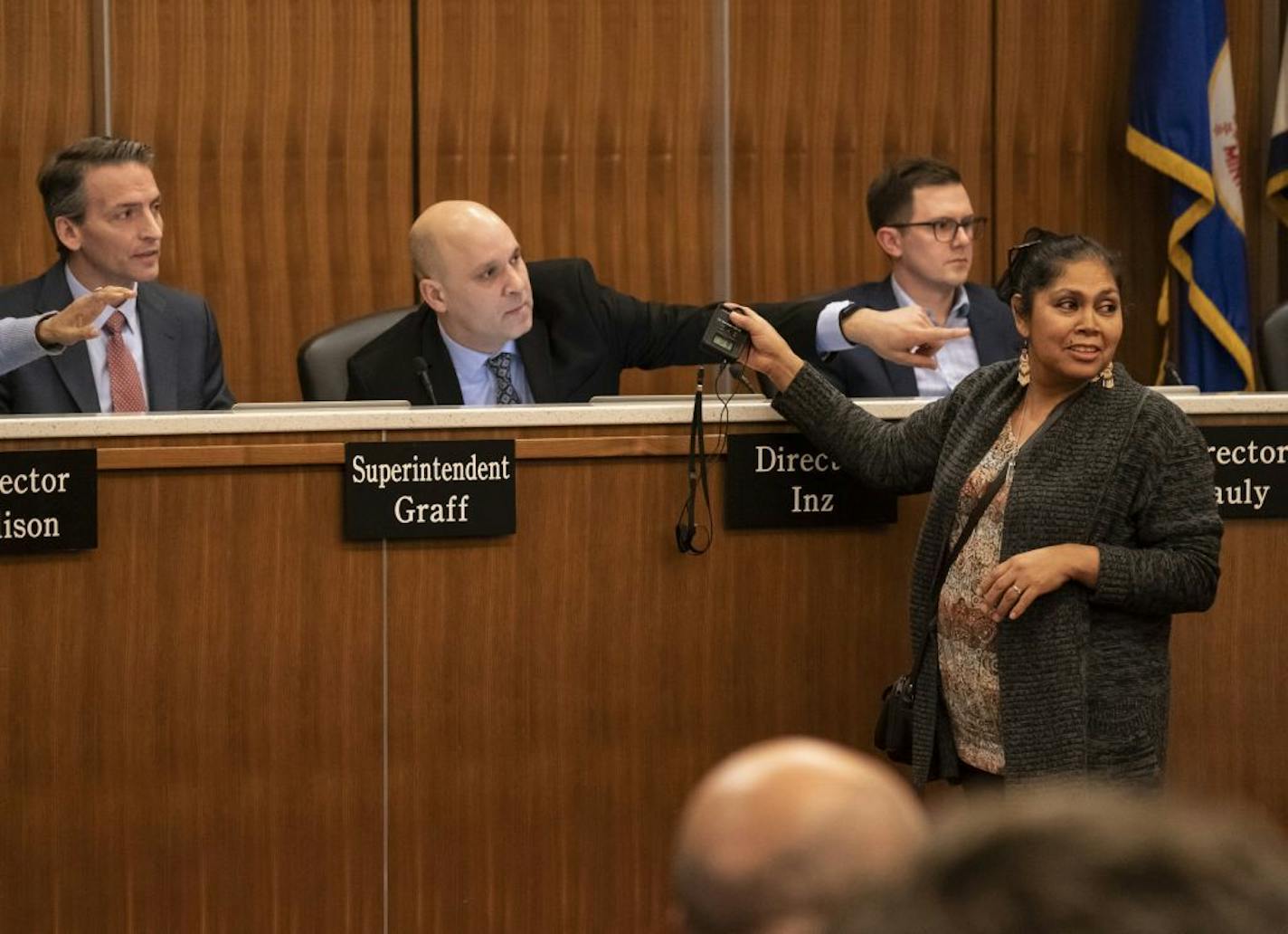 Maria Cisneros brought up her Spanish interpretation headphones to school board member Nelson Inz when it didn't work at the Minneapolis School Board meeting in Minneapolis, Minn., Tuesday, January 14, 2020. The meeting went to recess when there were several microphone issues causing more tension in the crowd. Many parents attended to voice their concerns about the district's strategic plan.