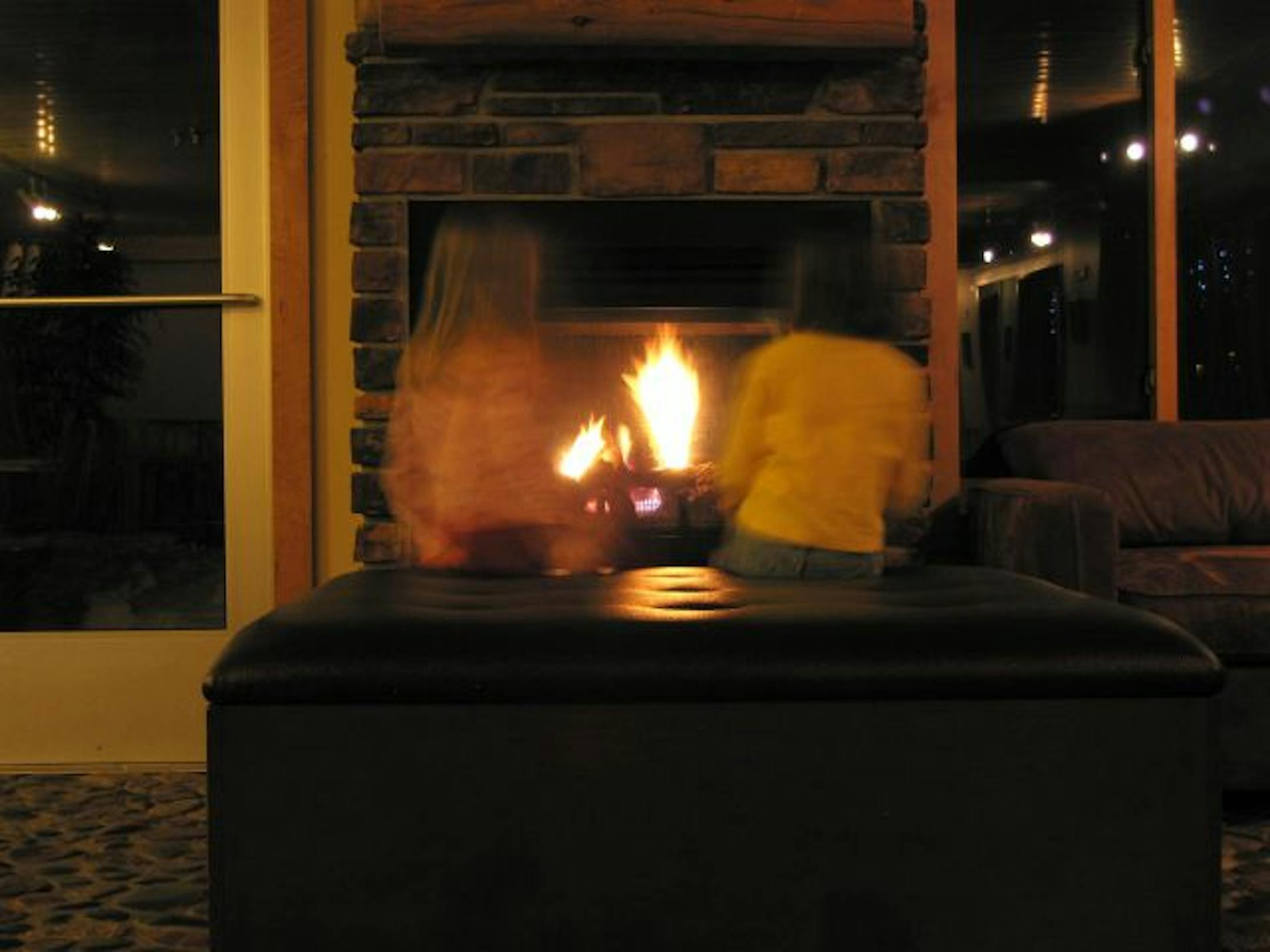 A fireplace warms children at the East Bay Suites, on the lake in Grand Marais, Minn. The fireplace opens to the beachside of the hotel, ready to warm anyone frolicking outside, too.