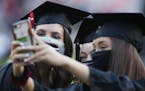 Graduates take a selfie before the start of the University of Georgia's rescheduled Spring Commencement at Sanford Stadium in Athens, Ga., Friday, Oct