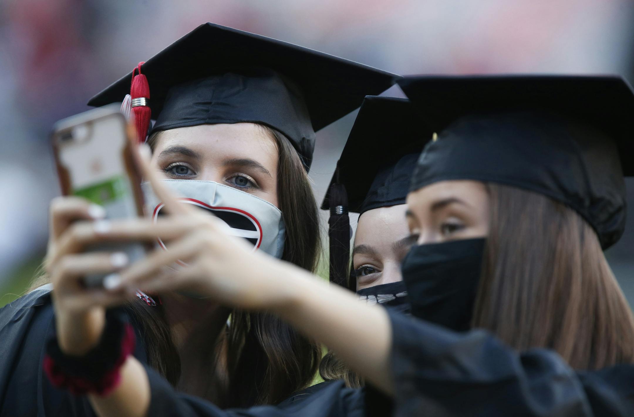Graduates take a selfie before the start of the University of Georgia's rescheduled Spring Commencement at Sanford Stadium in Athens, Ga., Friday, Oct. 16, 2020. The ceremony was moved from the spring due to the ongoing COVID-19 pandemic. (Joshua L. Jones/Athens Banner-Herald via AP)