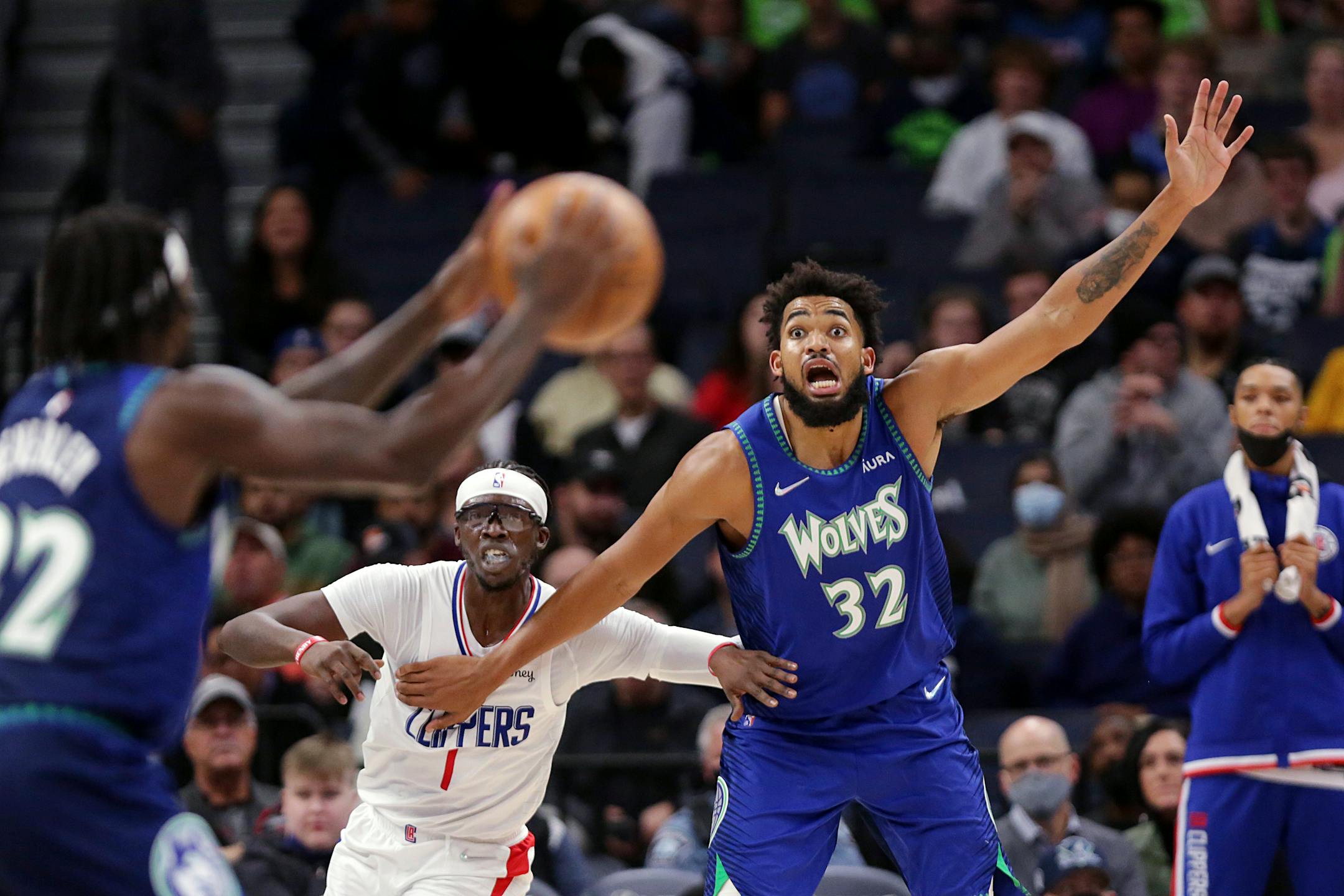 Minnesota Timberwolves center Karl-Anthony Towns (32) calls for the ball from guard Patrick Beverley (22) with Los Angeles Clippers guard Reggie Jackson (1) defends during the second half of an NBA basketball game, Friday, Nov. 5, 2021, in Minneapolis. (AP Photo/Andy Clayton-King)